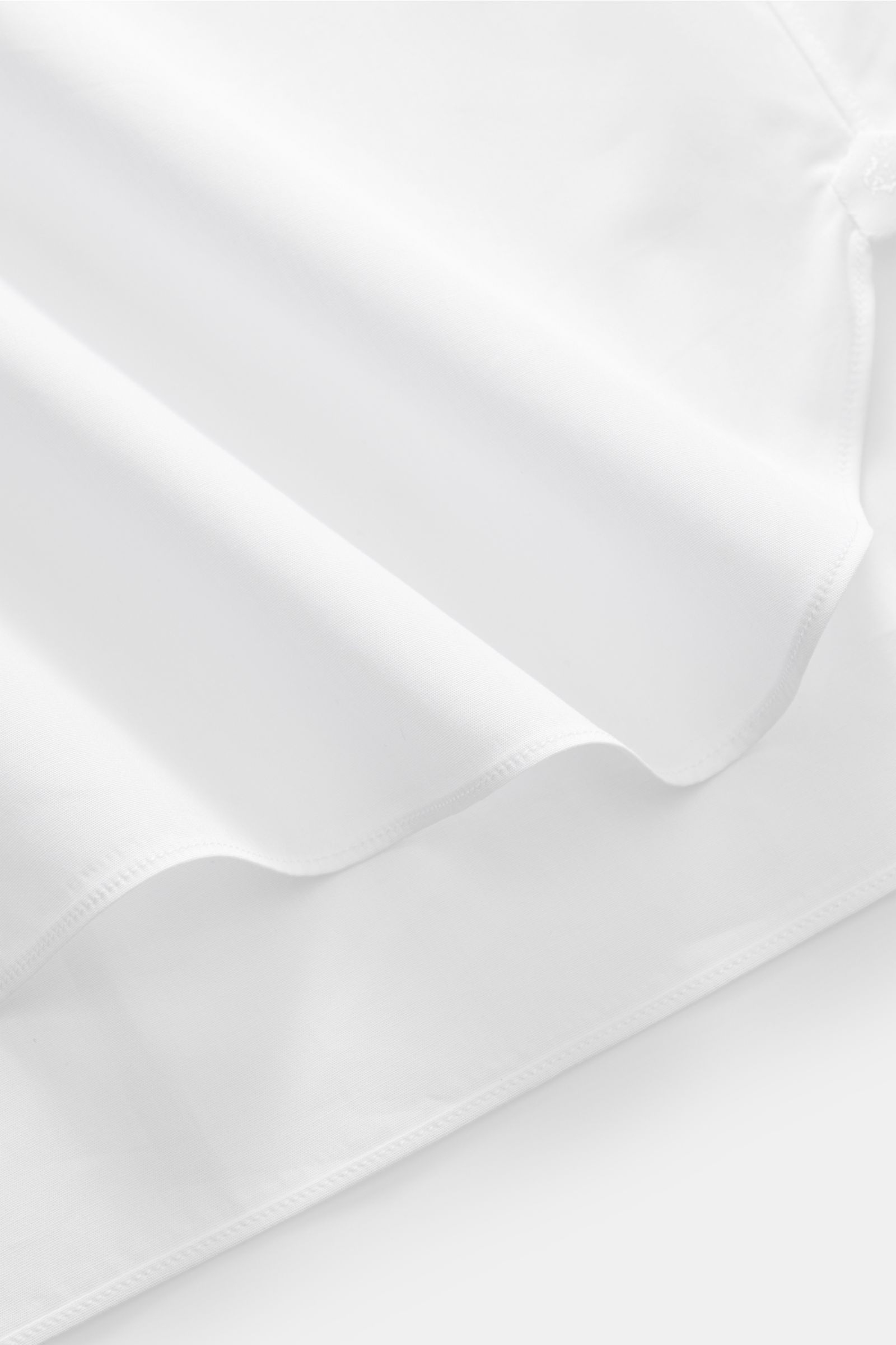 Blick auf den gerundeten Saum des Borrelli Smokinghemds 'Quinto' Kent-Kragen weiß aus Baumwolle mit plissierter Front.
