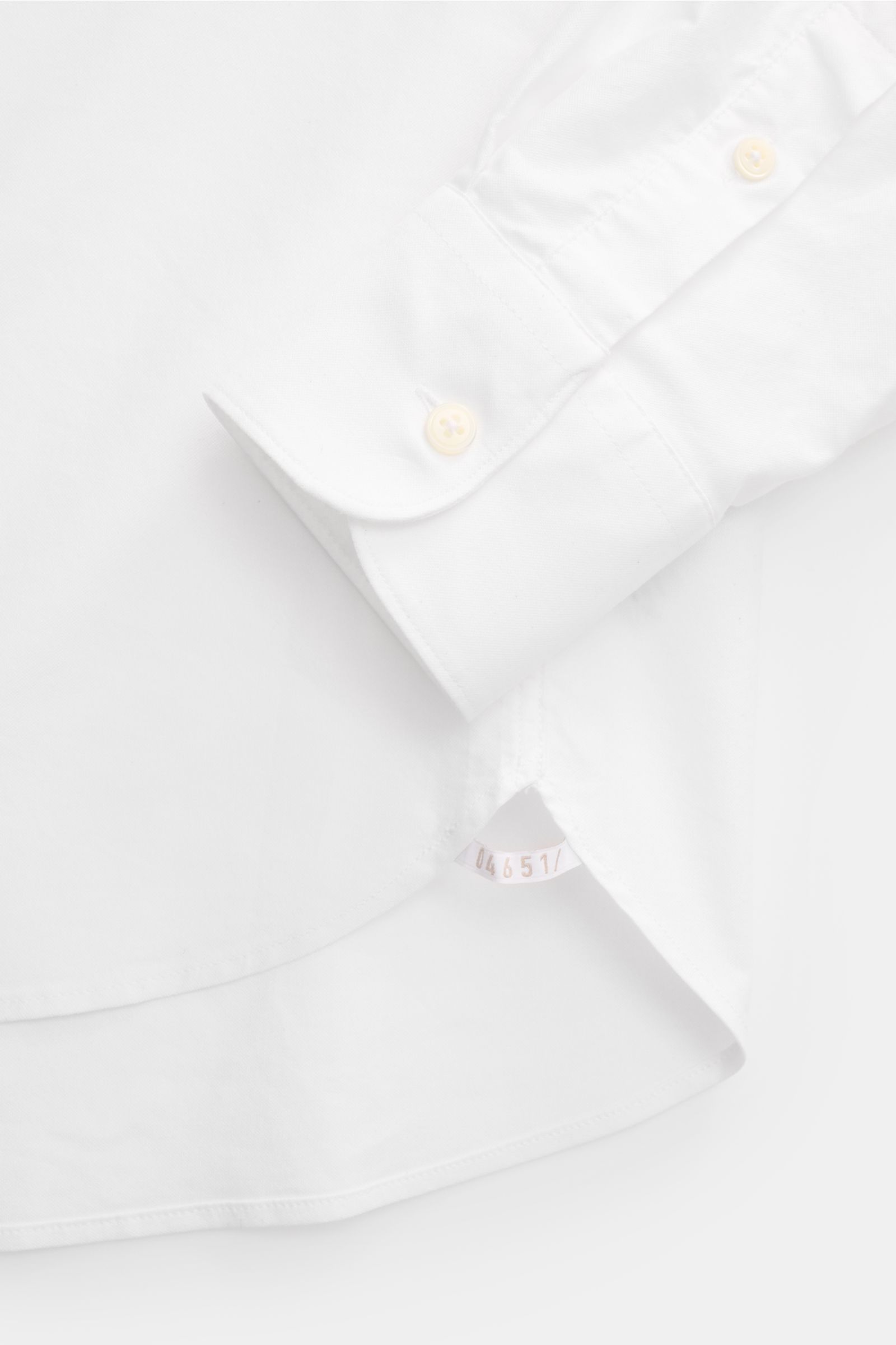 Close-up of the cuff and hem of the 04651/ A trip in a bag Oxford-Hemd Kent-Kragen weiß, photographed from above.

Dieses klassisch schlichte Oxford-Hemd mit Kent-Kragen von 04651/ A TRIP IN A BAG wurde aus reiner Baumwolle gefertigt und ist das perfek