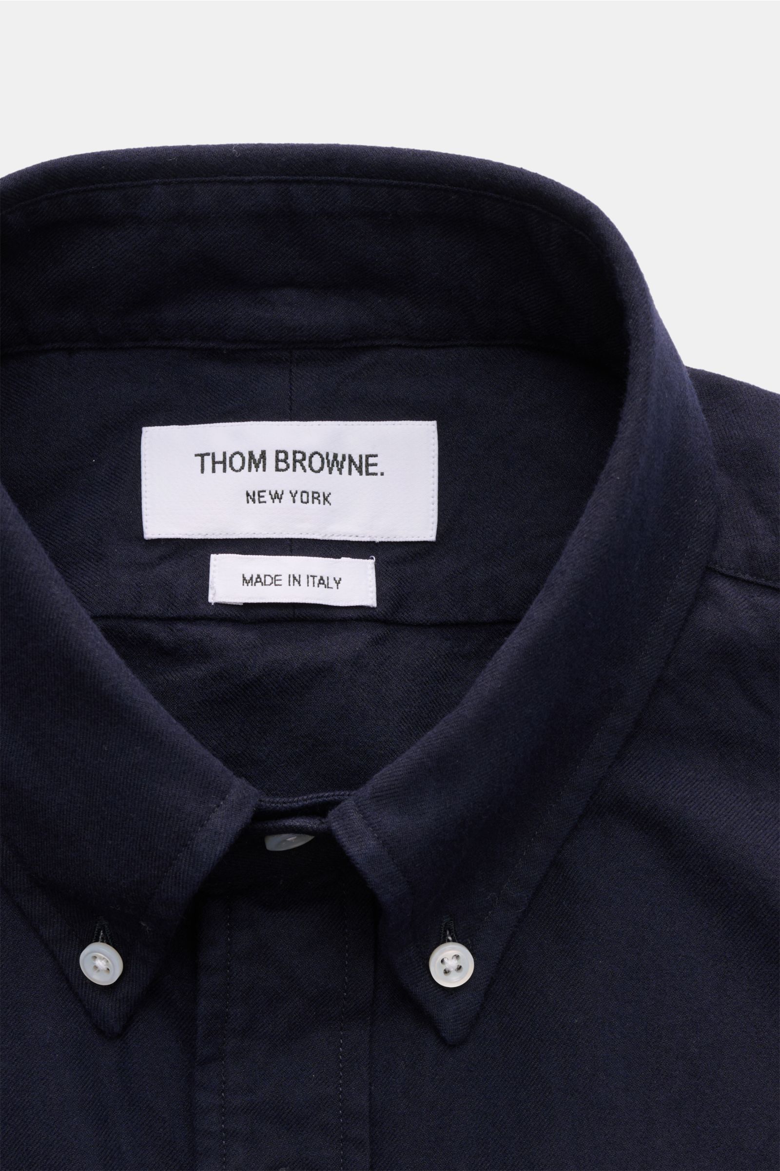 Nahaufnahme aus Frontperspektive des Thom Browne Flanellhemd Button-Down-Kragen navy mit weichem Griff, reiner Baumwolle, Knöpfen am Kragen, aufgesetzter Knopfleiste und klassischem Label.
