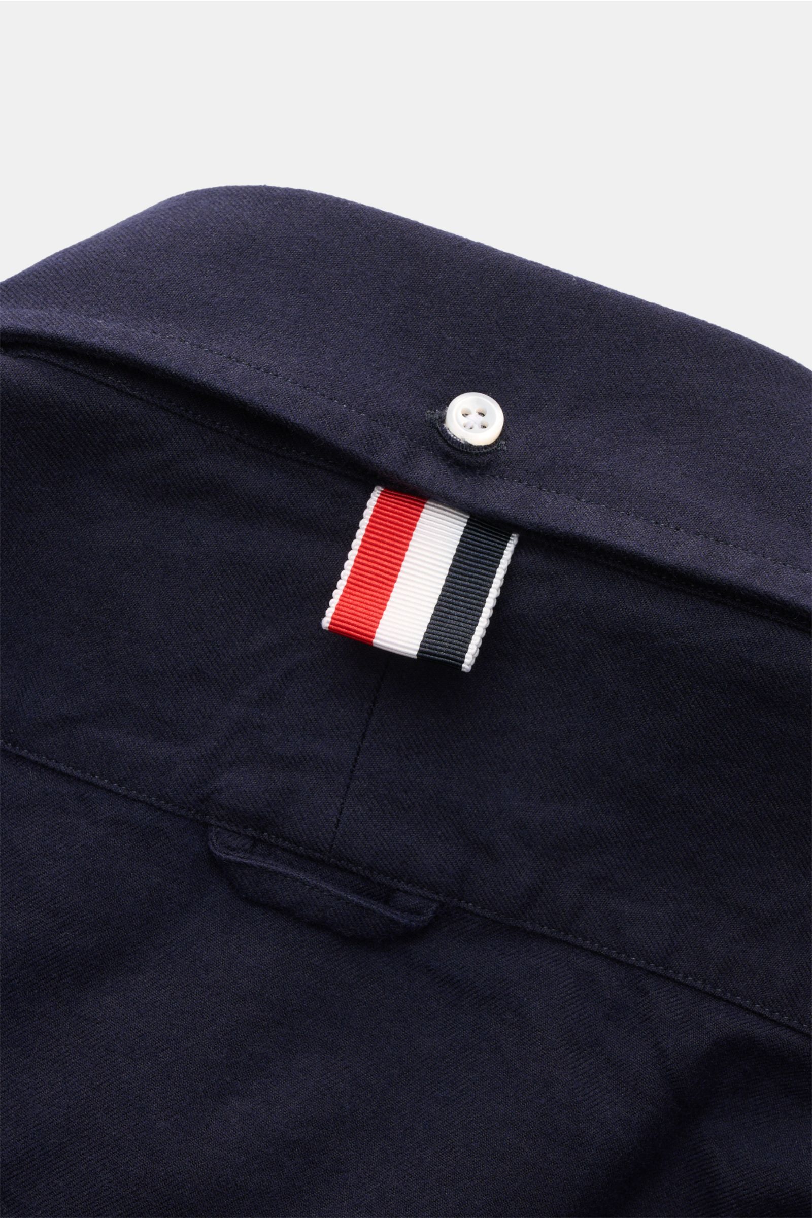 Thom Browne Flanellhemd Button-Down-Kragen navy, Detailaufnahme Rückseite mit weißem Knopf und markantem Streifenband, reine Baumwolle, soft, casual.