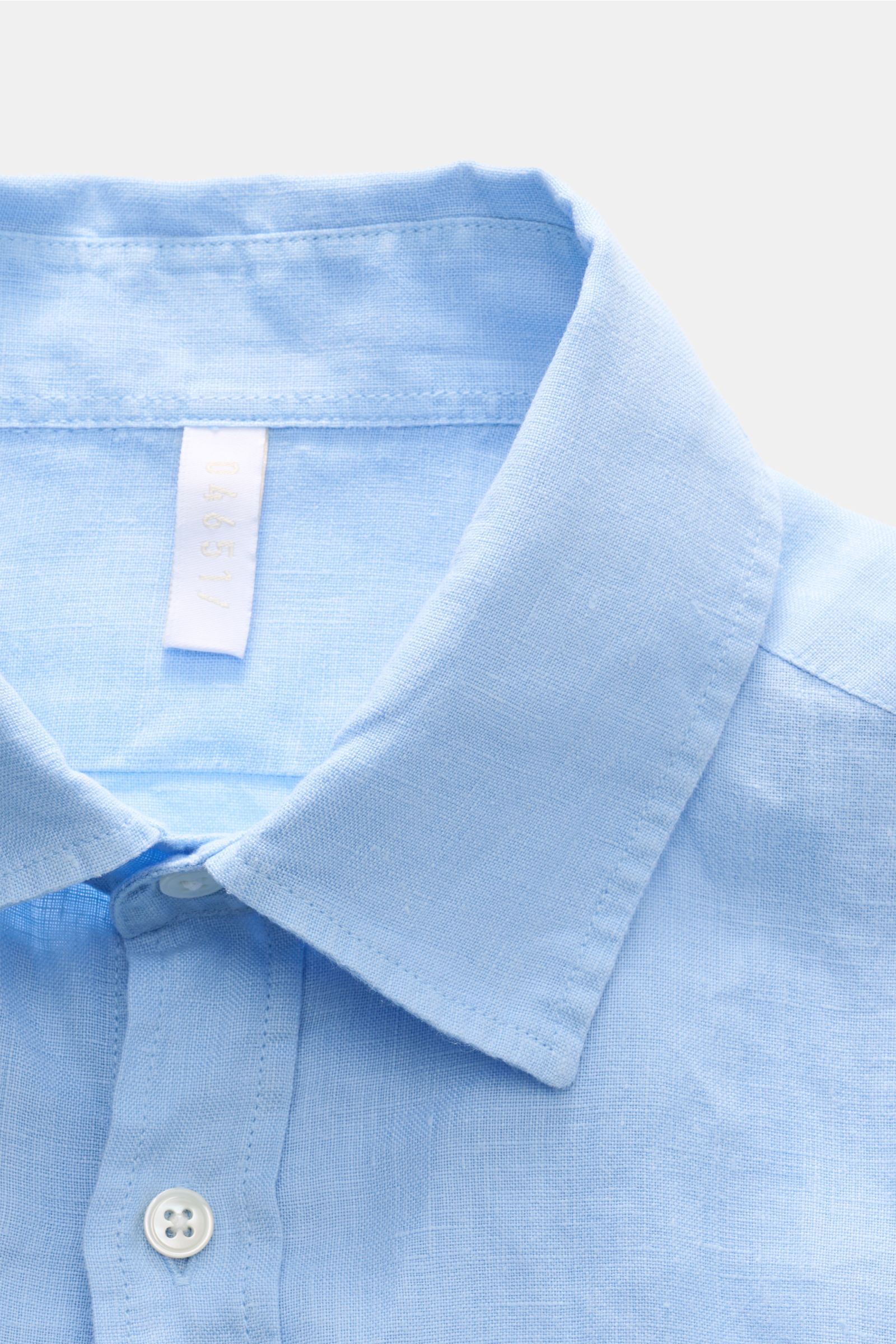 Close-up front view of the light blue 04651/ A trip in a bag Leinenhemd Kent-Kragen hellblau showcasing its Kent collar, button placket, and linen texture. Mühelose Leichtigkeit