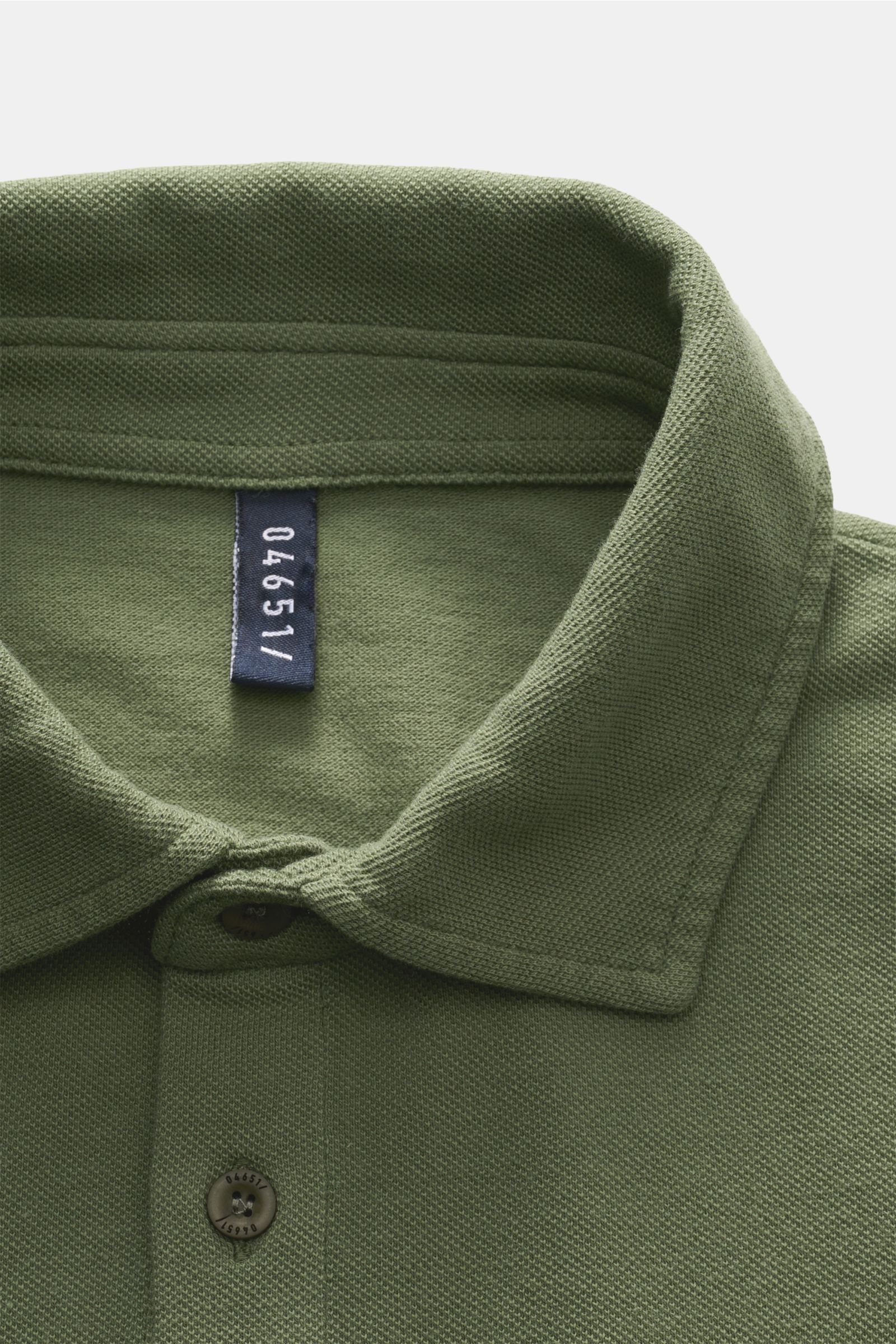 Grünes 04651/ A trip in a bag Hemd Sport aus Baumwollstoff, Nahaufnahme von oben mit sichtbarem Etikett im Kragen.