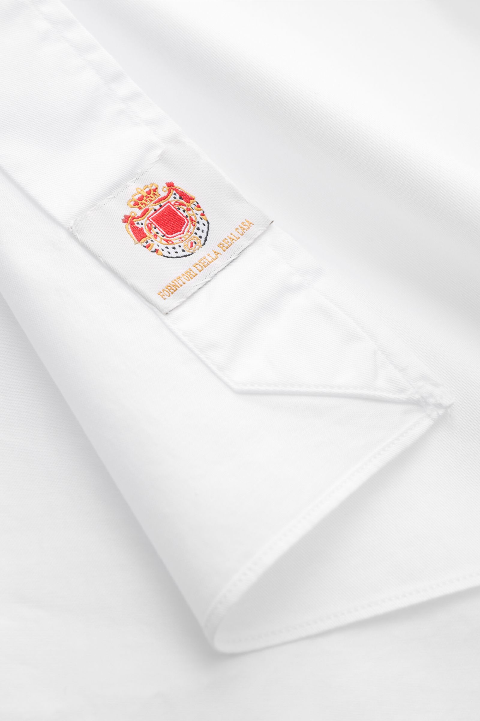 Nahaufnahme des Ärmels mit Label des Borrelli Casual Hemd 'Ettore' Haifisch-Kragen weiß aus Twill, glattem Griff, Slim Fit, Haifisch-Kragen, französischer Knopfleiste mit Perlmuttknöpfen, klassischer Sportmanschette und gerundetem Saum, fotografiert von s