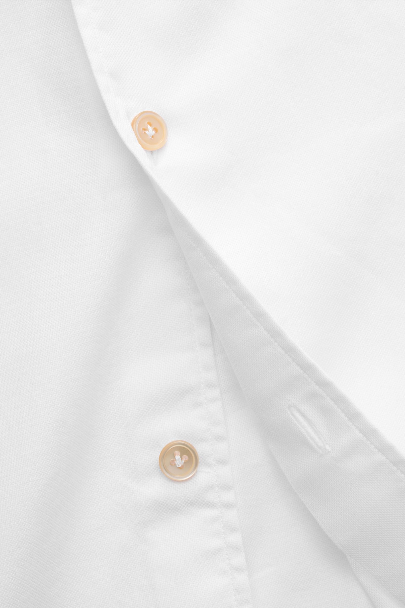 Close-up front view of Borrelli Oxford-Hemd 'Ettore' Haifisch-Kragen weiß, showing buttons and fabric texture. Oxford aus reiner Baumwolle, glatter Griff, Slim Fit, Haifisch-Kragen, französische Knopfleiste mit Perlmuttknöpfen, klassische Sportmanschette,