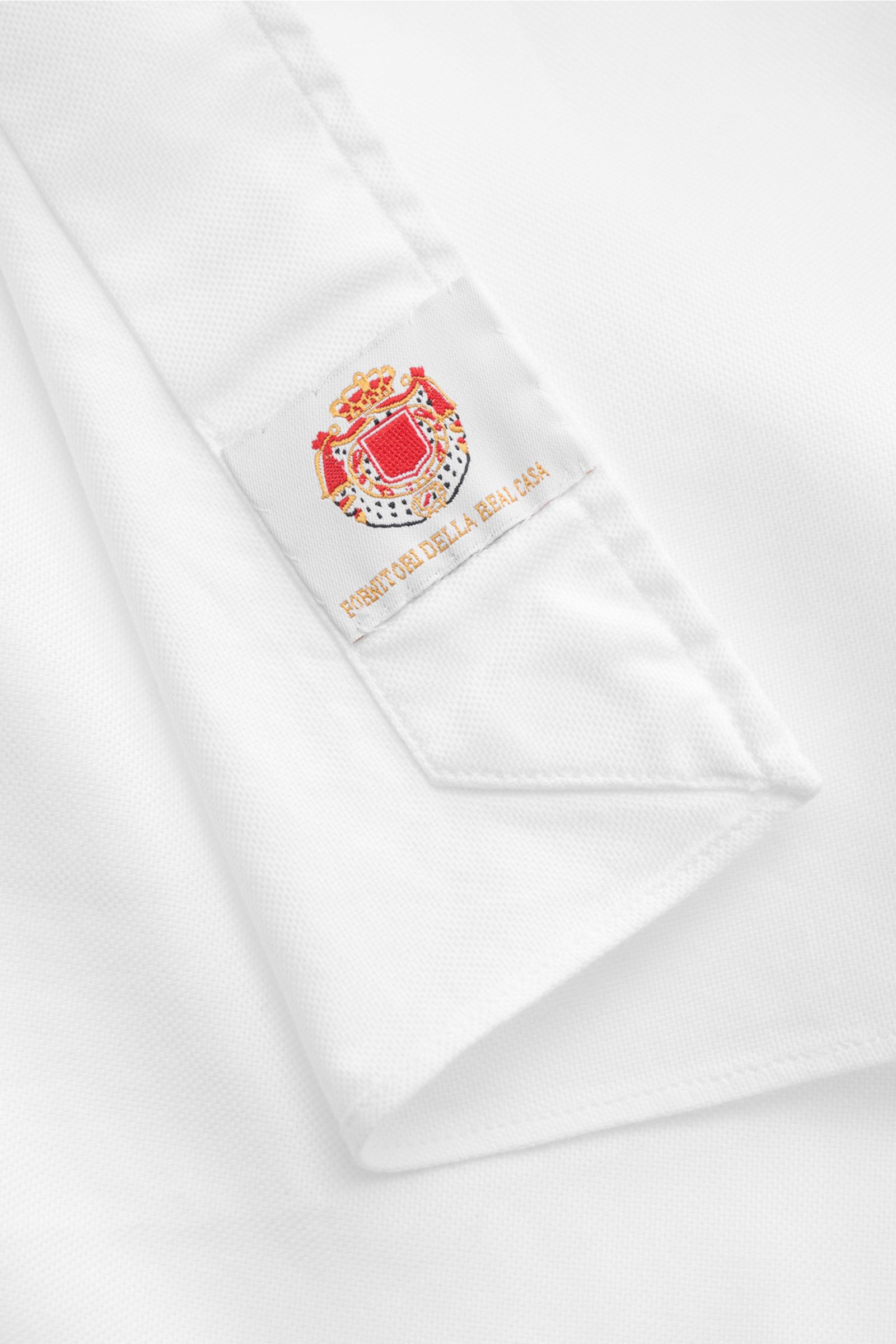 Close-up image of the cuff of the Borrelli Oxford-Hemd 'Ettore' Haifisch-Kragen weiß, photographed from an angled top view, showing Oxford aus reiner Baumwolle, glatter Griff, Slim Fit, Haifisch-Kragen, französische Knopfleiste mit Perlmuttknöpfen, klassi