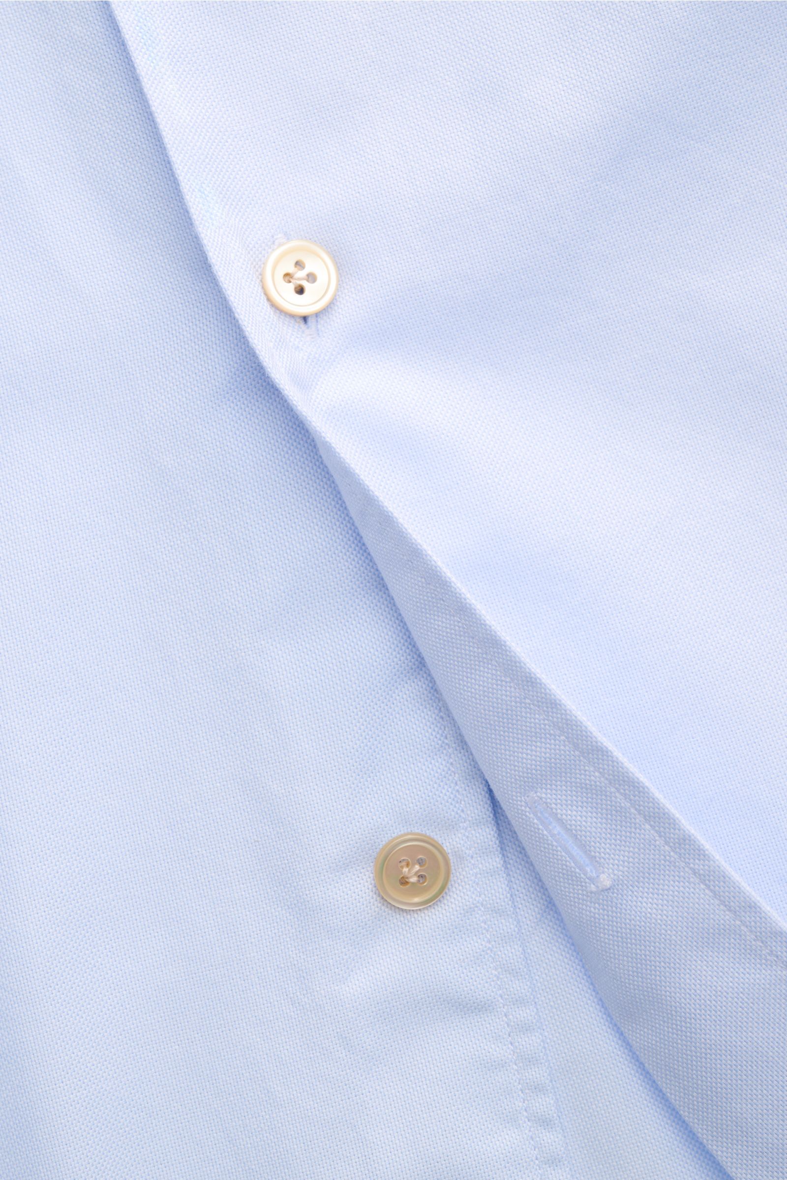 Nahaufnahme des Borrelli Oxford-Hemds 'Ettore' Button-Down-Kragen hellblau, Oxford aus reiner Baumwolle, glatter Griff, Slim Fit, französische Knopfleiste mit Perlmuttknöpfen, klassische Sportmanschette und gerundeter Saumverlauf, aus schräger Perspektive