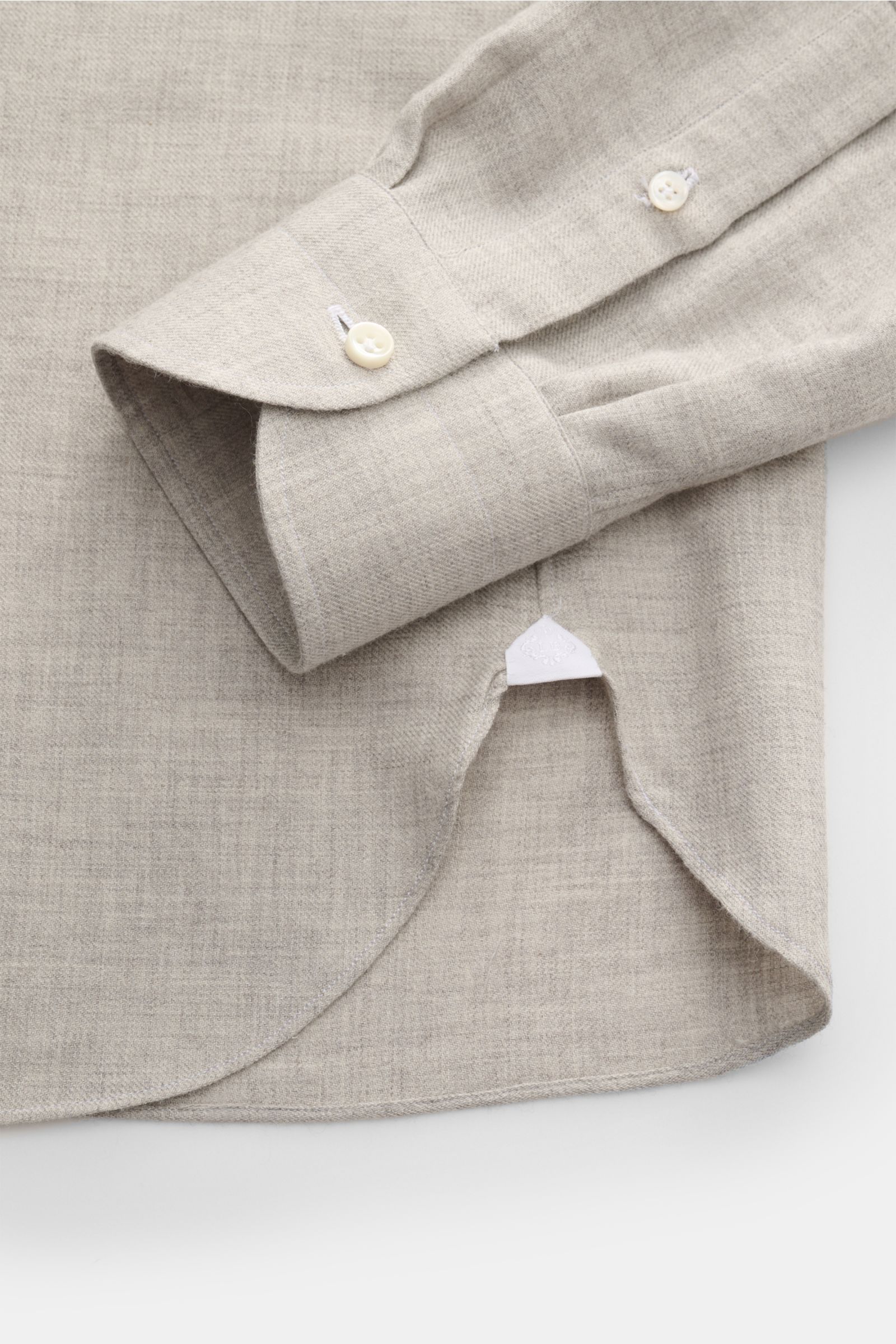 Close-up view of the cuff and rounded hem of the Borrelli Flannel shirt 'Ettore' shark collar grey mottled, twill in cotton and wool, brushed, smooth feel, slim fit, French button placket with mother-of-pearl buttons, and classic barrel cuffs.