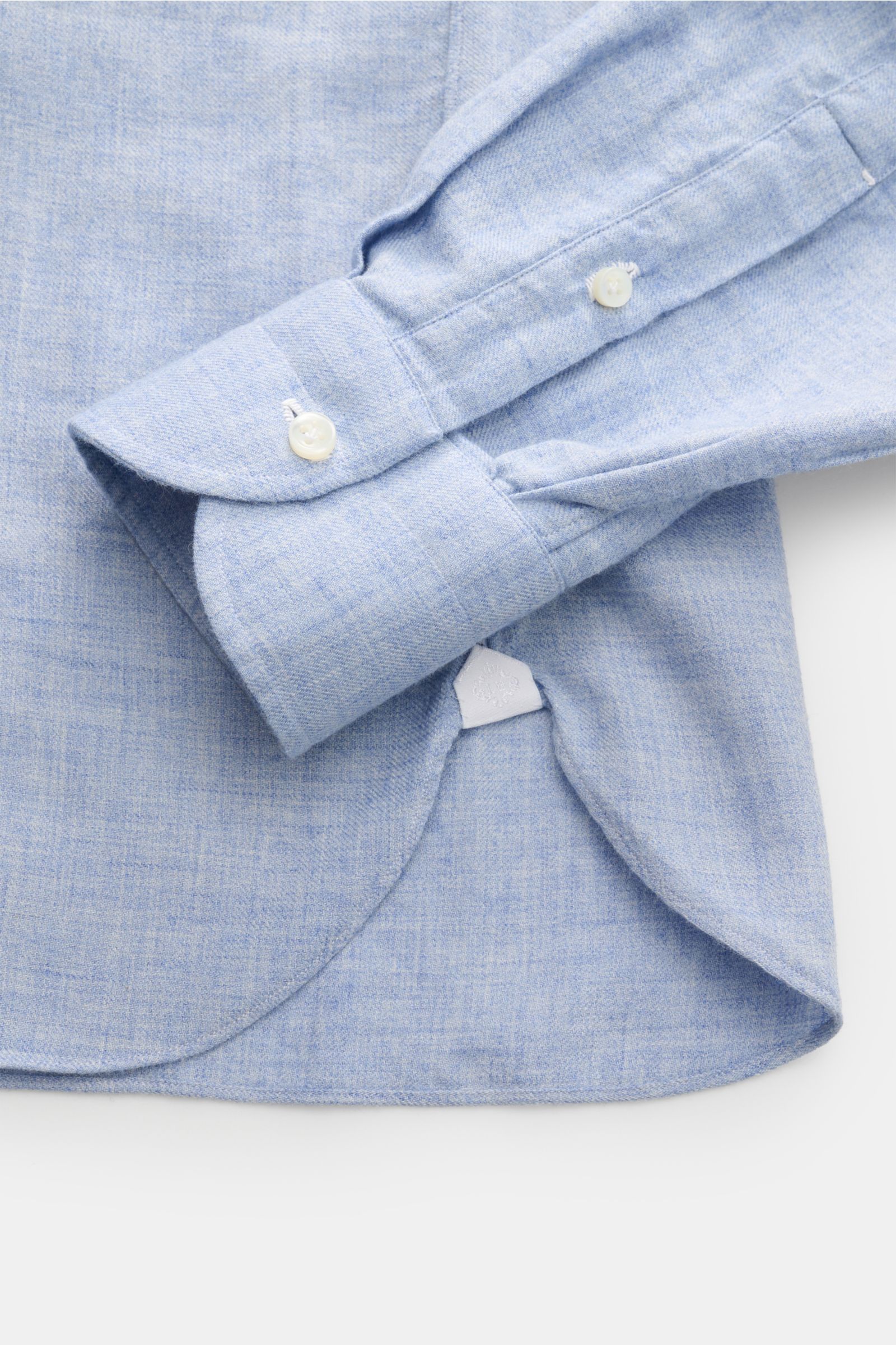 Close-up image from above of the sleeve and hem of the Borrelli Flanellhemd 'Ettore' Haifisch-Kragen hellblau meliert, showing twill aus Baumwolle und Wolle, angeraut, glatter Griff, Slim Fit, Haifisch-Kragen, französische Knopfleiste mit Perlmuttknöpfen,