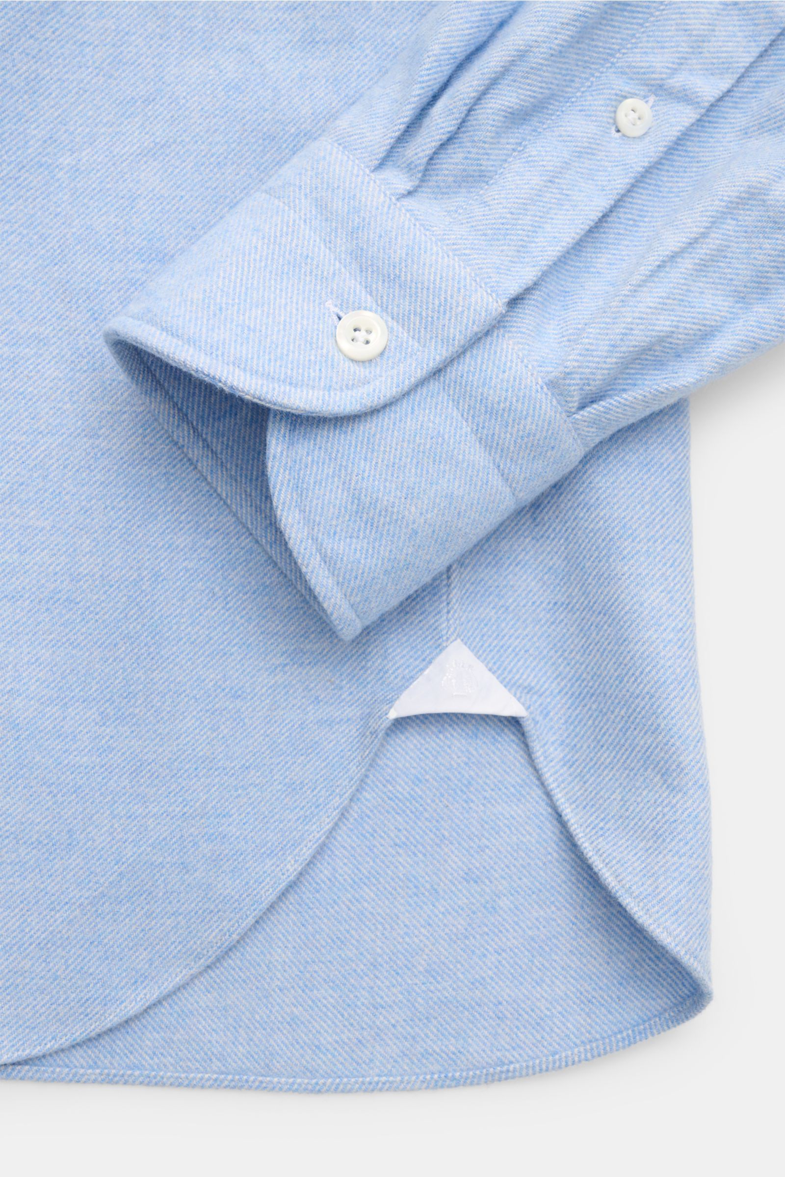 Nahaufnahme des Giampaolo Flanellhemds Haifisch-Kragen hellblau meliert mit Twill, softer Griff, angerauter Oberfläche, Slim Fit, französischer Knopfleiste und klassischer Sportmanschette, fotografiert von unten auf den gerundeten Saumverlauf und Manschet