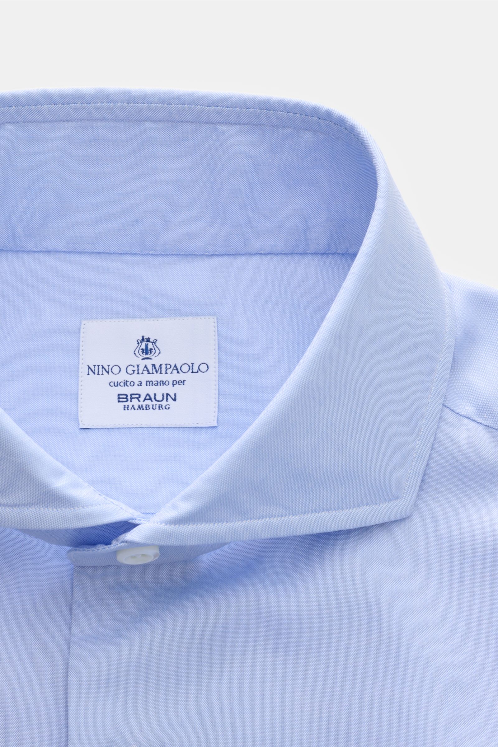 Close-up front view of Giampaolo Casual Hemd Haifisch-Kragen hellblau in light blue, featuring a shark collar, pure cotton, slim fit, soft smooth texture, mother-of-pearl buttons, French placket, classic sport cuffs, back waist darts, and rounded hem.

