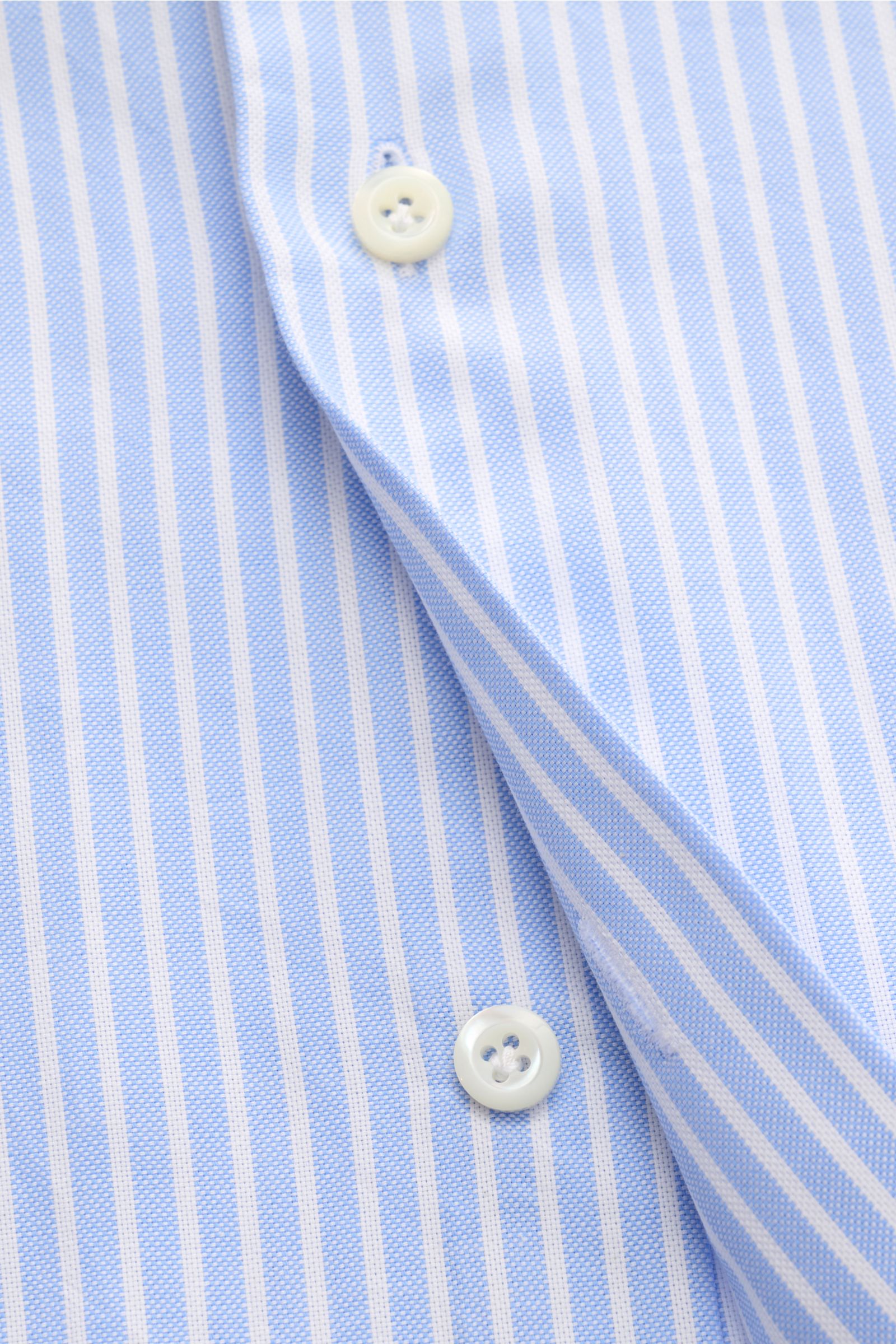 Close-up front view of the Giampaolo Oxford-Hemd Haifisch-Kragen hellblau/weiß gestreift showing blue and white stripes, buttons, and fabric texture. Oxford aus reiner Baumwolle, weicher, leicht strukturierter Griff, Slim Fit, Haifisch-Kragen, französisch
