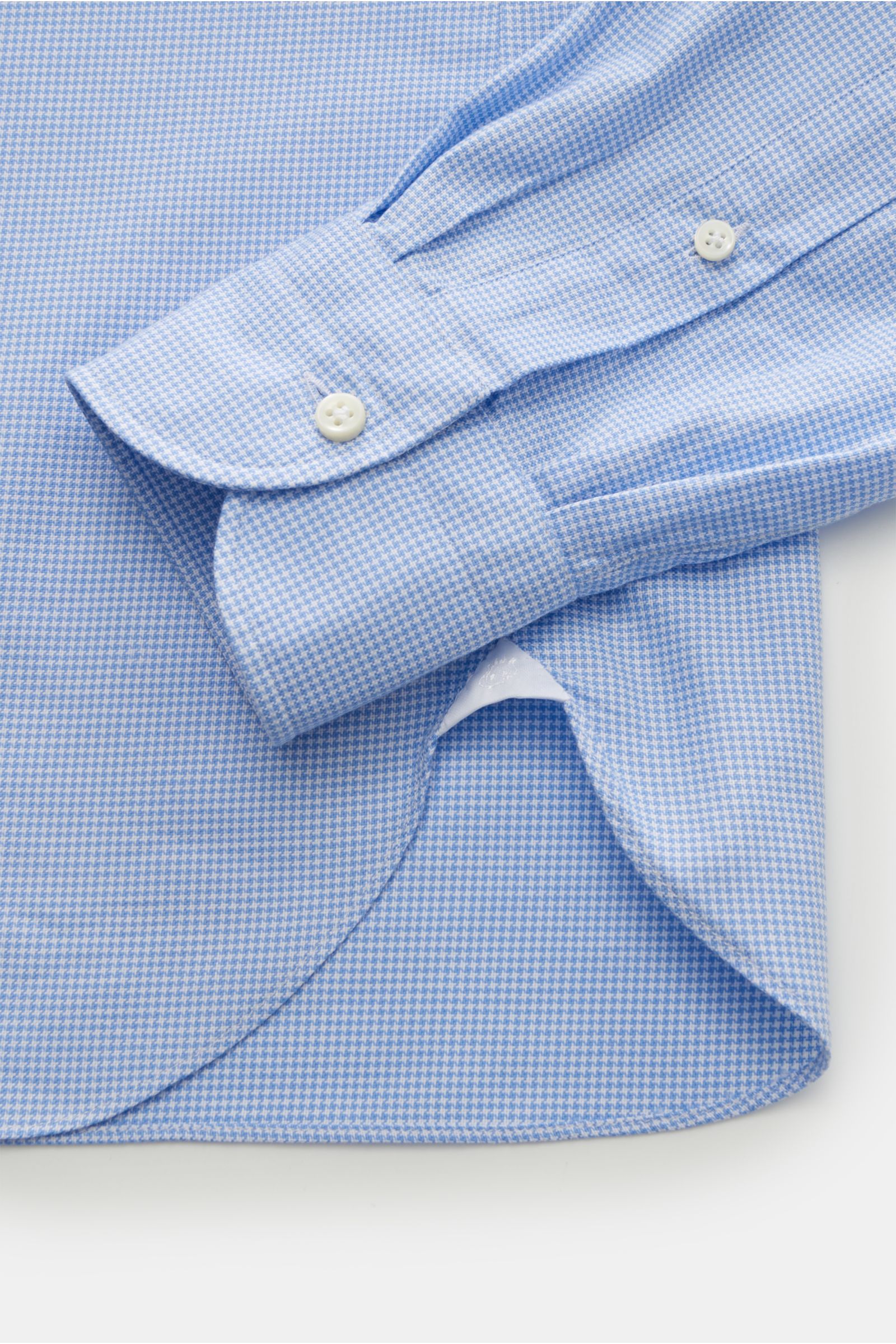Giampaolo Oxford-Hemd Haifisch-Kragen hellblau/weiß kariert shown from a close-up top view of the cuff and hem. Oxford aus reiner Baumwolle, weicher, leicht strukturierter Griff, Slim Fit, Haifisch-Kragen, französische Knopfleiste, klassische Sportmansche