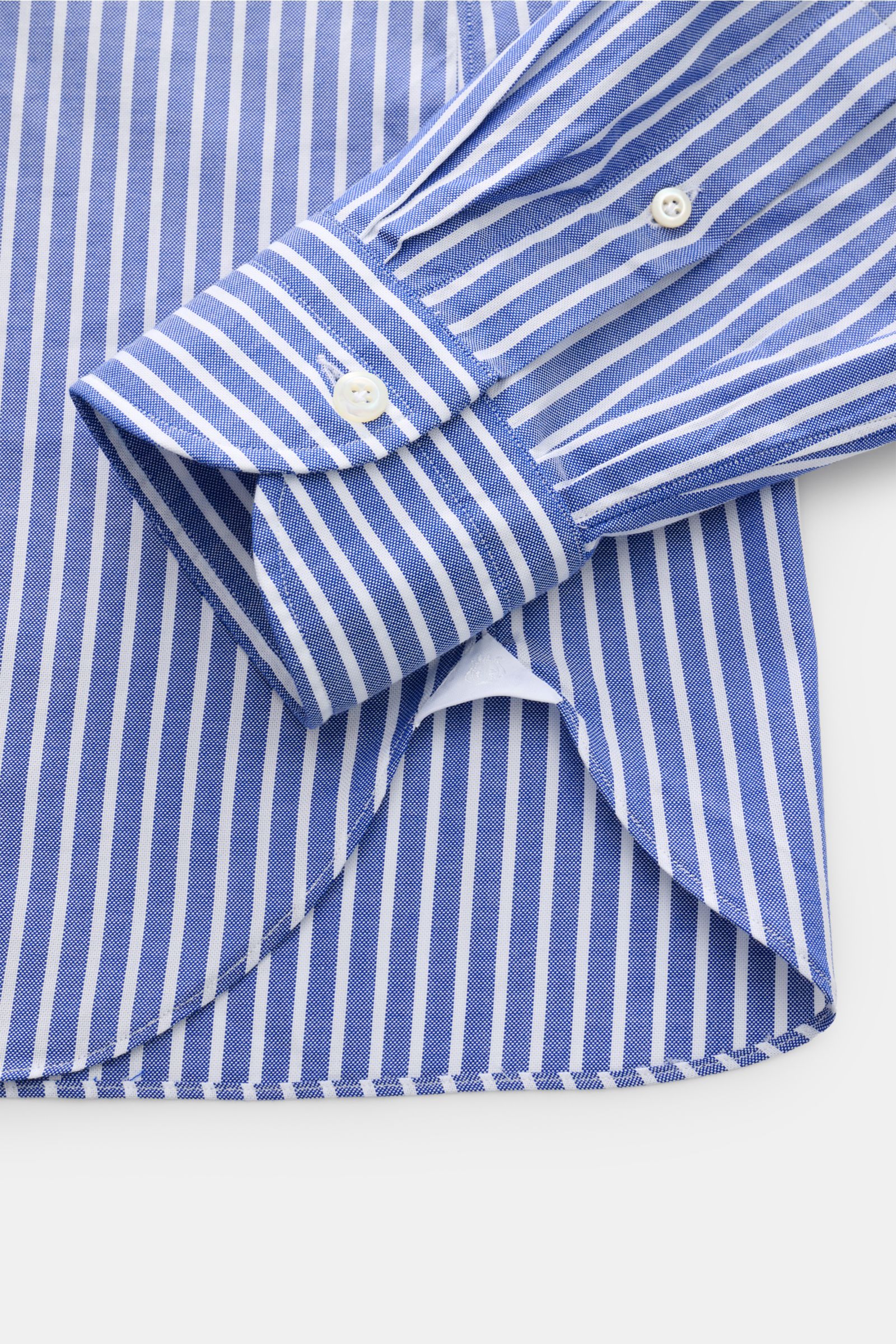 Close-up view from above of the cuff and hem of the Giampaolo Casual Hemd Haifisch-Kragen navy/weiß gestreift, featuring Panama pure cotton, lightly textured feel, Slim Fit, shark collar, French placket, classic sport cuff, back waist darts, and rounded h