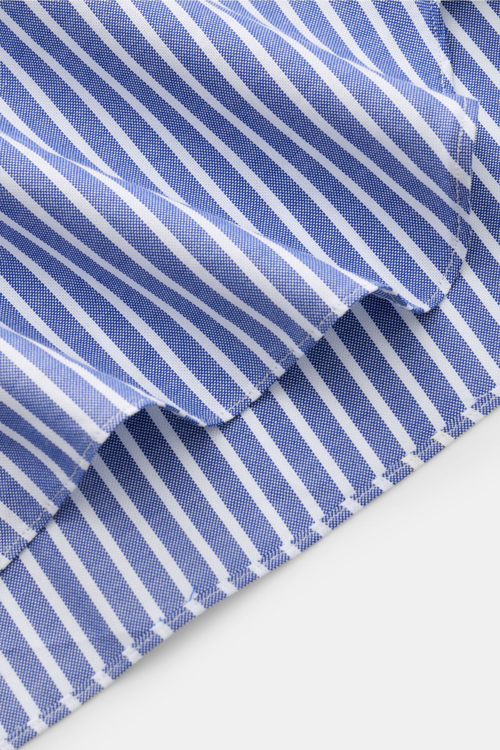 Close-up of the hem of the Giampaolo Casual Hemd Haifisch-Kragen navy/weiß gestreift, showing the fabric's navy and white stripes and stitching from a top-side perspective. Panama aus reiner Baumwolle, leicht strukturierter Griff, Slim Fit, Haifisch-Krage