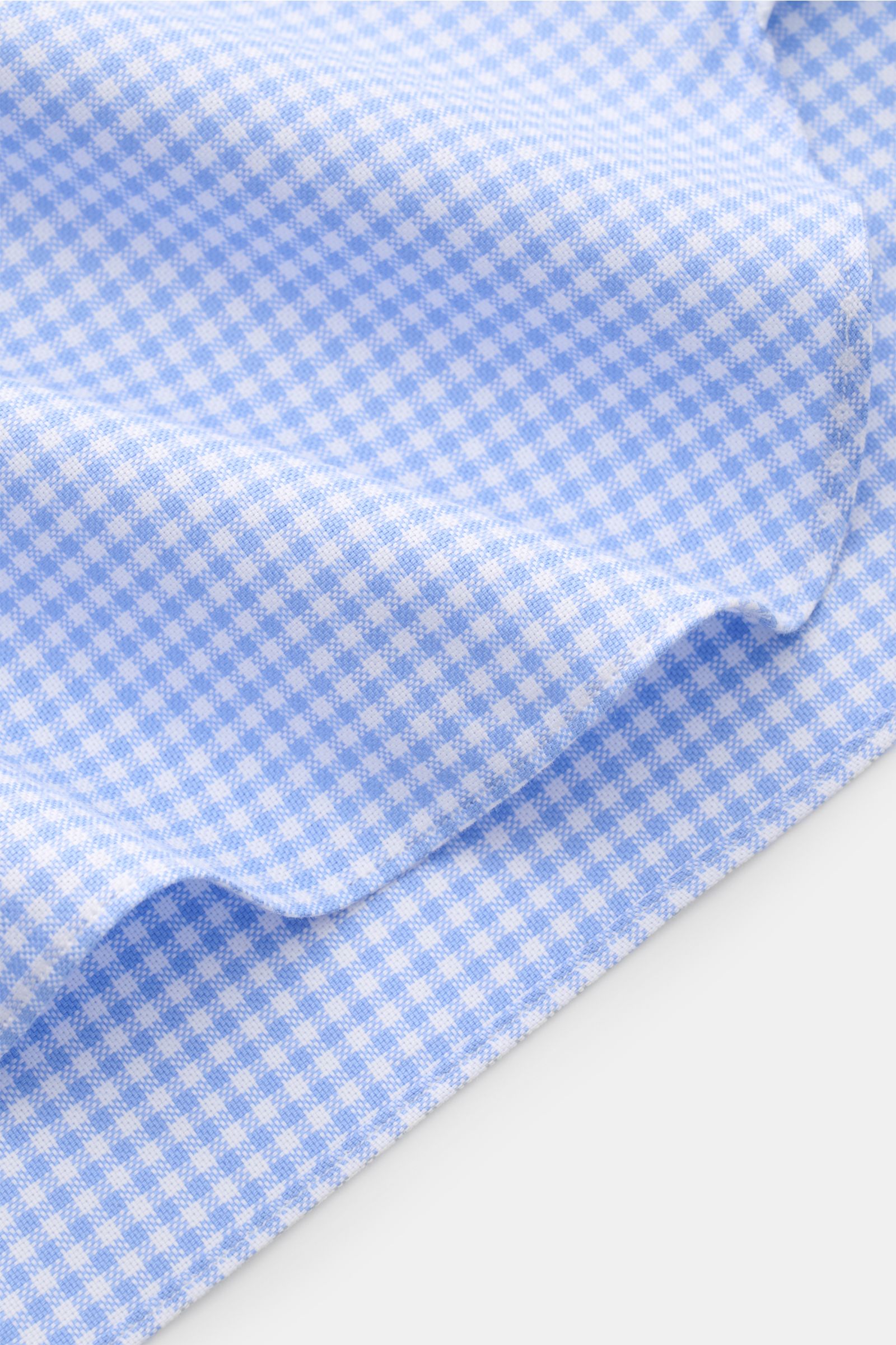 Nahaufnahme des gerundeten Saumverlaufs des Giampaolo Casual Hemd Haifisch-Kragen blau/weiß kariert, Panama reine Baumwolle, Slim Fit, französische Knopfleiste, klassische Sportmanschette, rückwärtige Taillenabnäher, leicht strukturierter Griff.