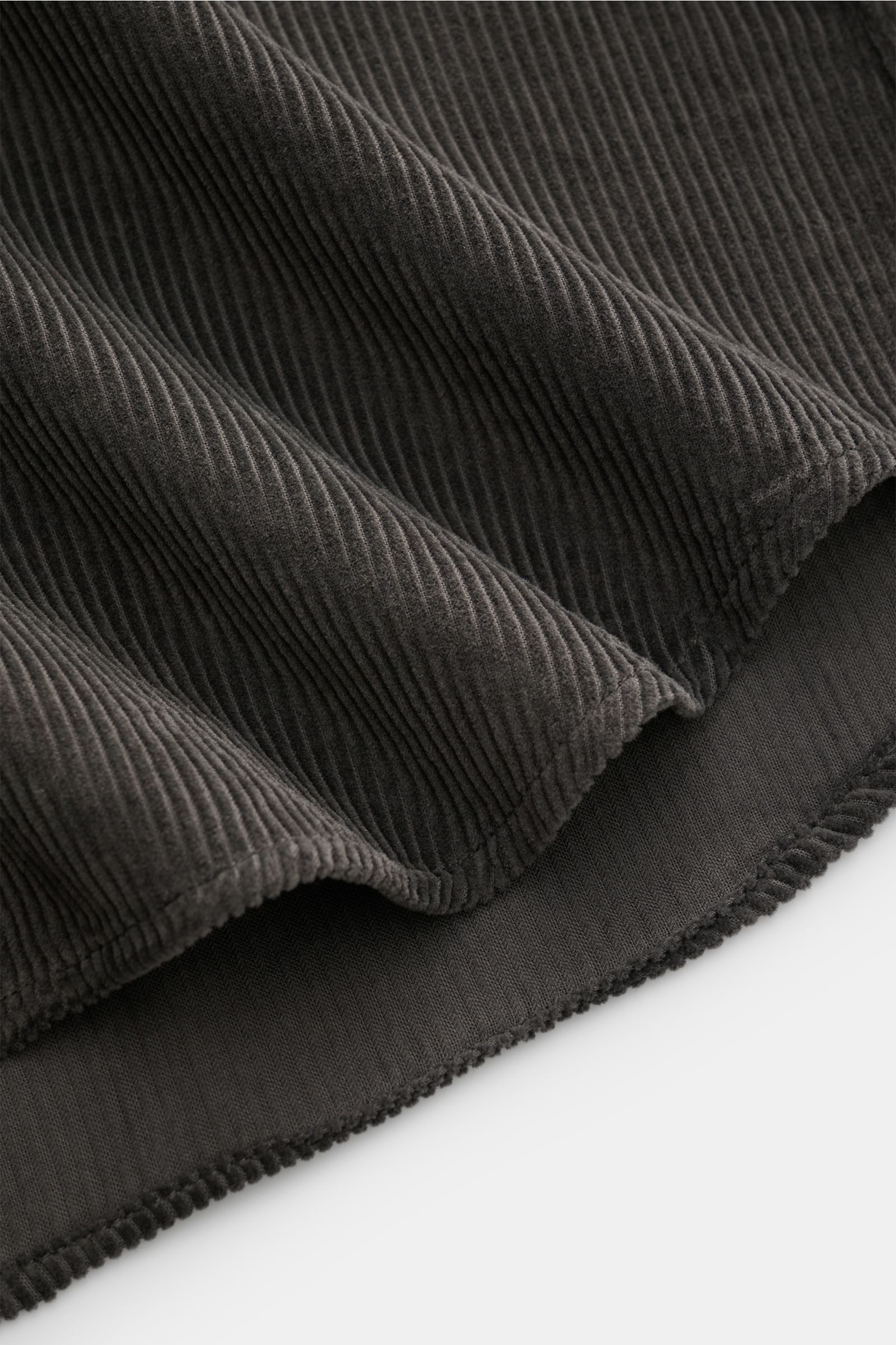 Nahaufnahme des weichen, warmen Baumwollcords vom Sonrisa Cordhemd Haifisch-Kragen dunkelgrau mit leicht gerundetem Saum.