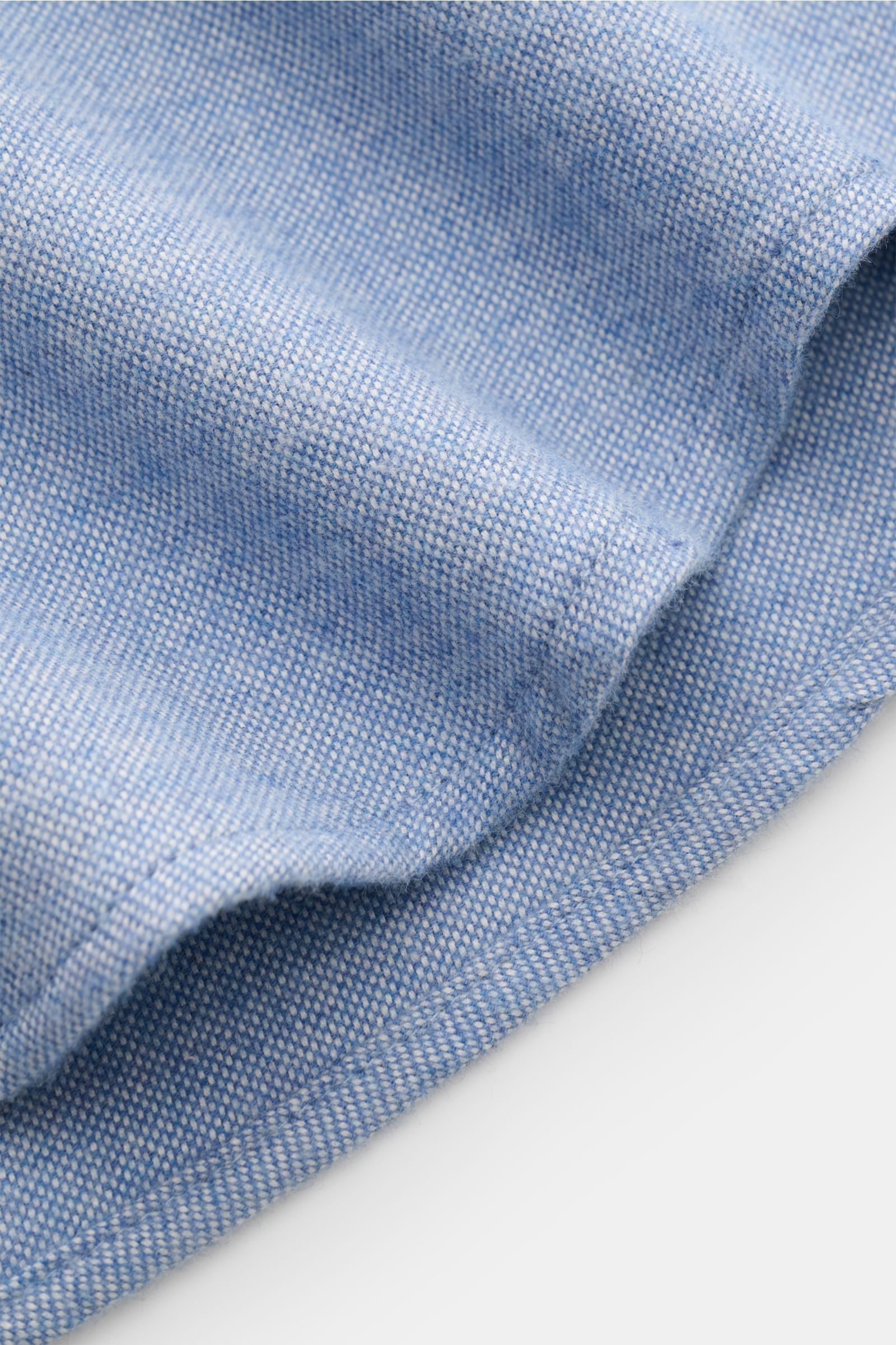 Nahaufnahme des weichen Materials des Sonrisa Oxford-Hemds Haifisch-Kragen rauchblau aus 100% Baumwolle mit leicht gerundetem Saum.