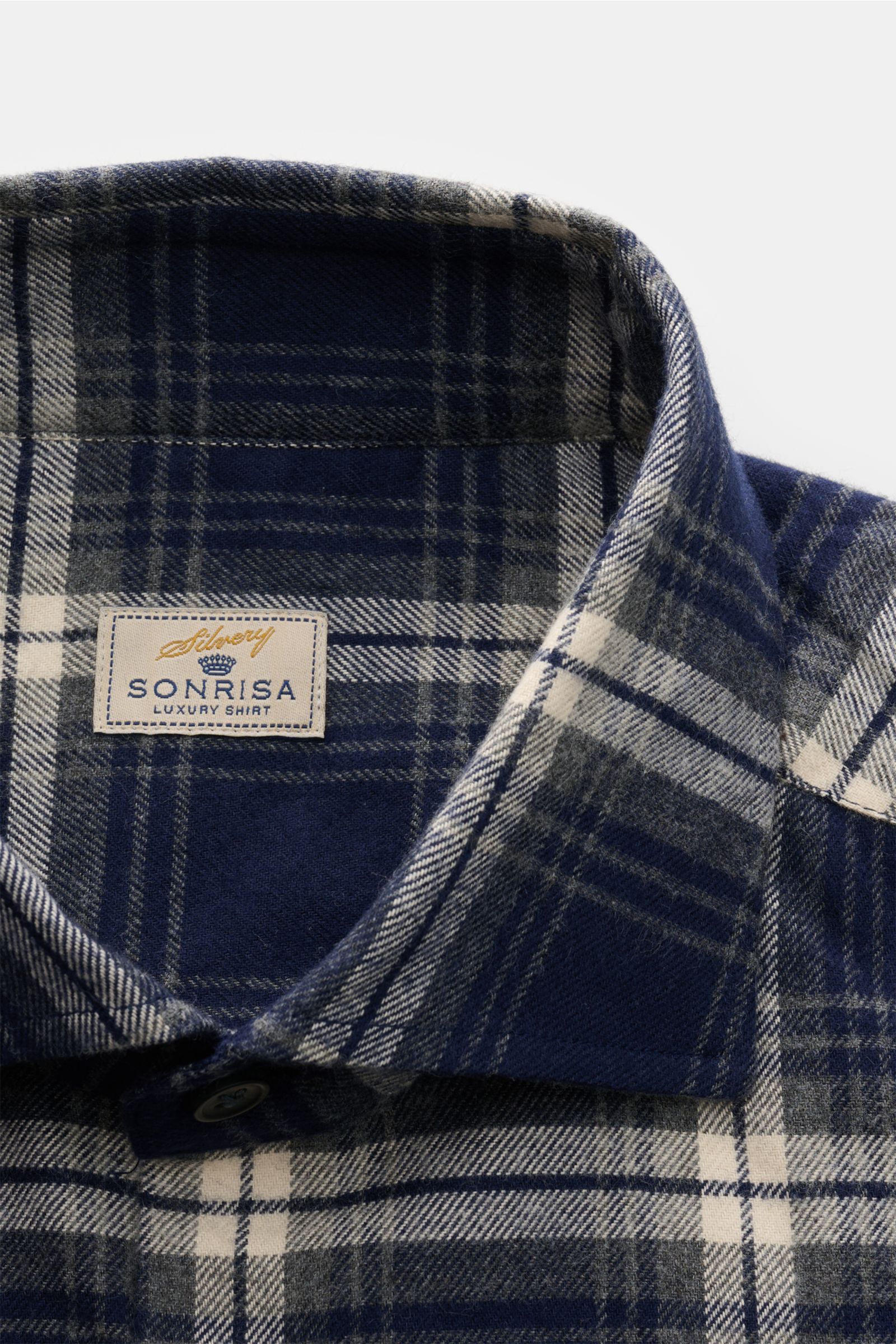Close-up front view of the Sonrisa Flanellhemd Haifisch-Kragen navy/grau/offwhite kariert, showing soft cotton flannel, classic plaid, slim fit, shark collar, French placket, sport cuffs, rounded hem, and small woven label. Leger und komfortabel: Das v