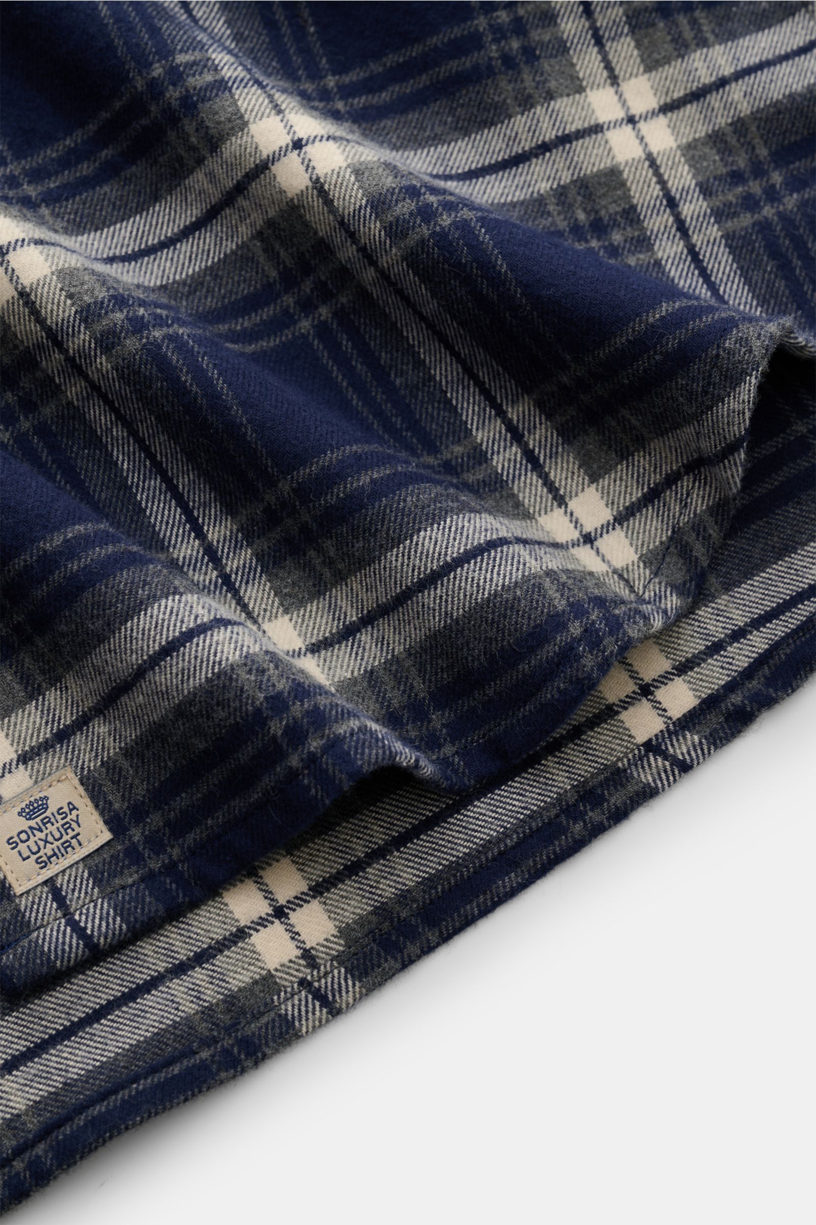 Close-up view of the Sonrisa Flanellhemd Haifisch-Kragen navy/grau/offwhite kariert showing soft cotton flannel with classic check pattern and small hem label. Leger und komfortabel: Das vielseitig einsetzbare Flanellhemd der Marke SONRISA wird mit seinem