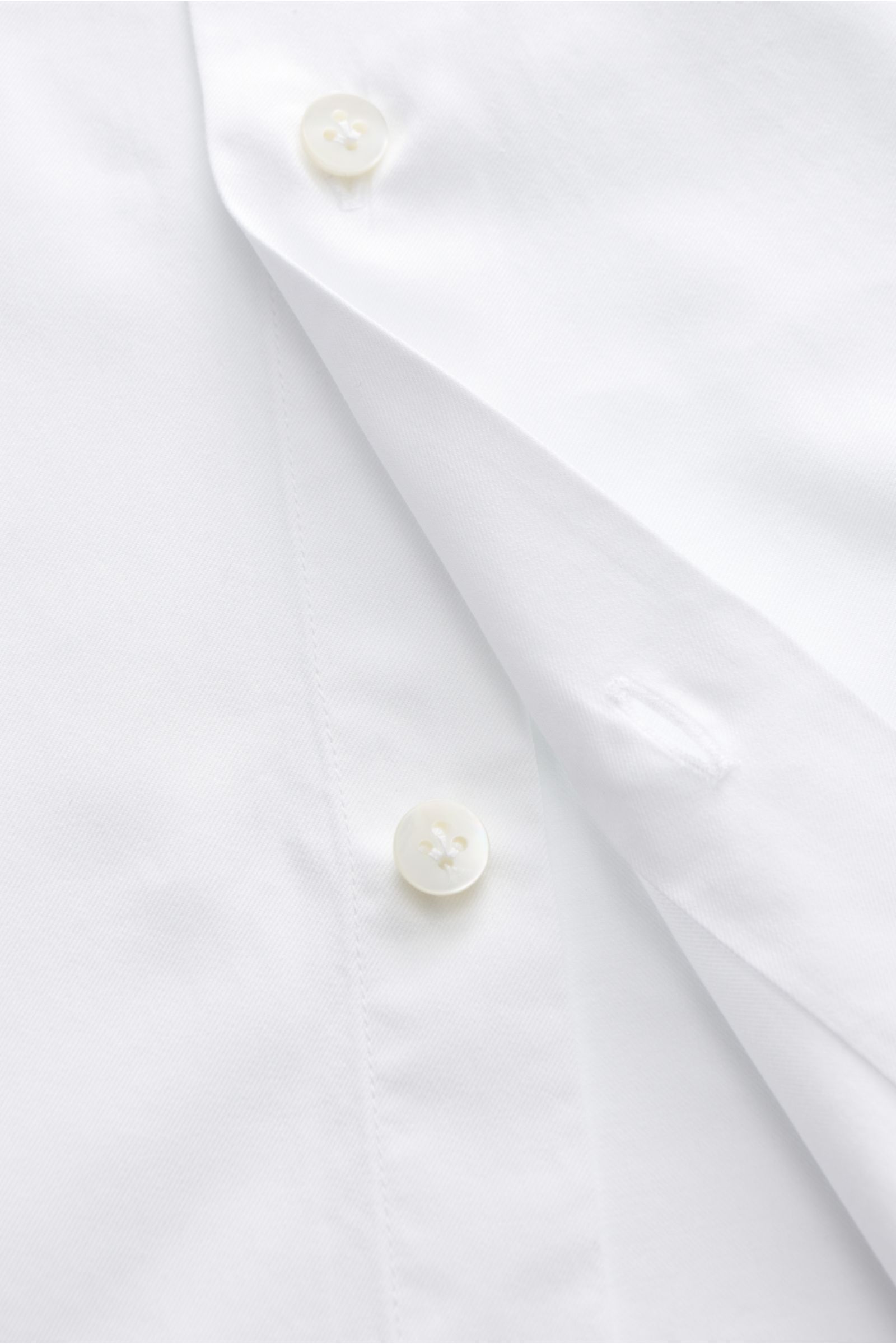 Close-up front view of the Guglielminotti Casual Hemd Haifisch-Kragen weiß showing white buttons and fine twill fabric. Features: 
- Twill aus reiner Baumwolle
- weicher, glatter Griff
- Regular Fit
- Haifisch-Kragen
- französische Knopfleiste
- klassisch
