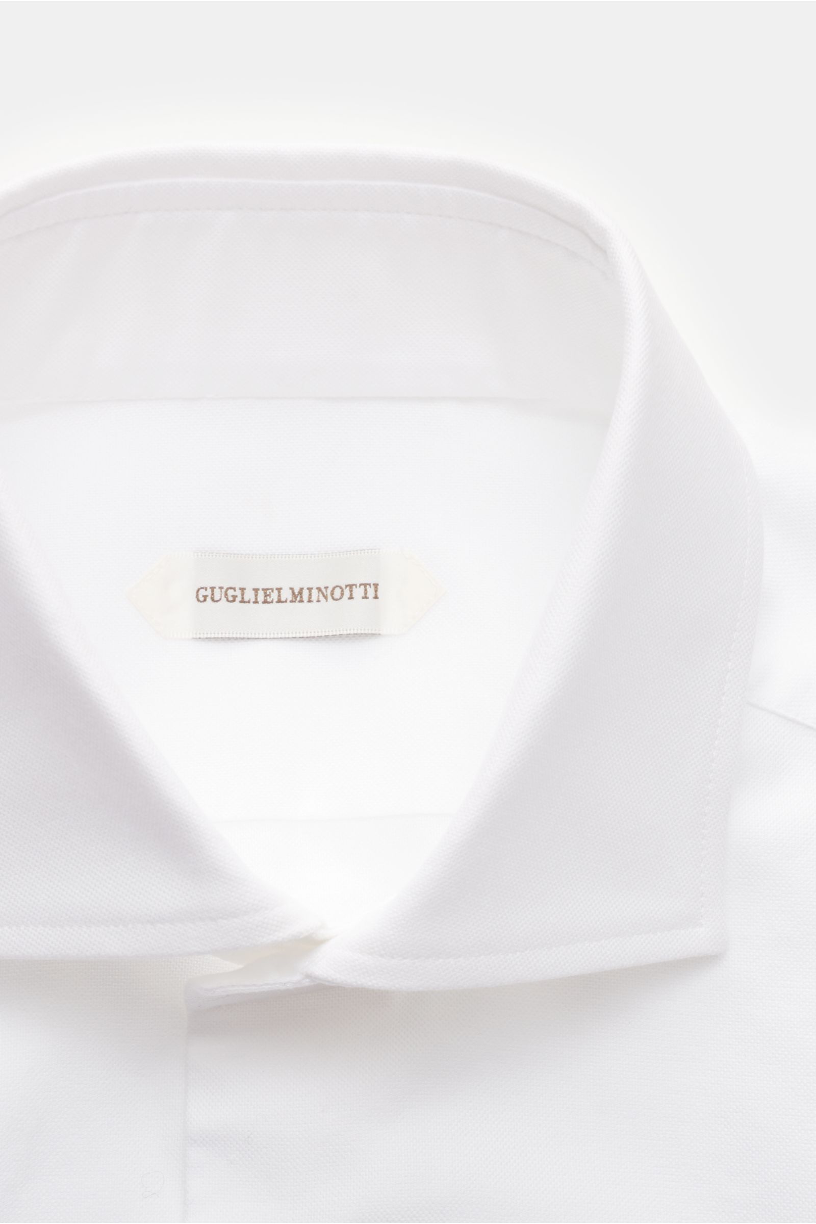 Guglielminotti Oxford-Hemd Haifisch-Kragen weiß, Slim Fit, reine Baumwolle, glatter Griff, französische Knopfleiste, Sportmanschette, Taillenabnäher, gerundeter Saum, Nahaufnahme von oben.