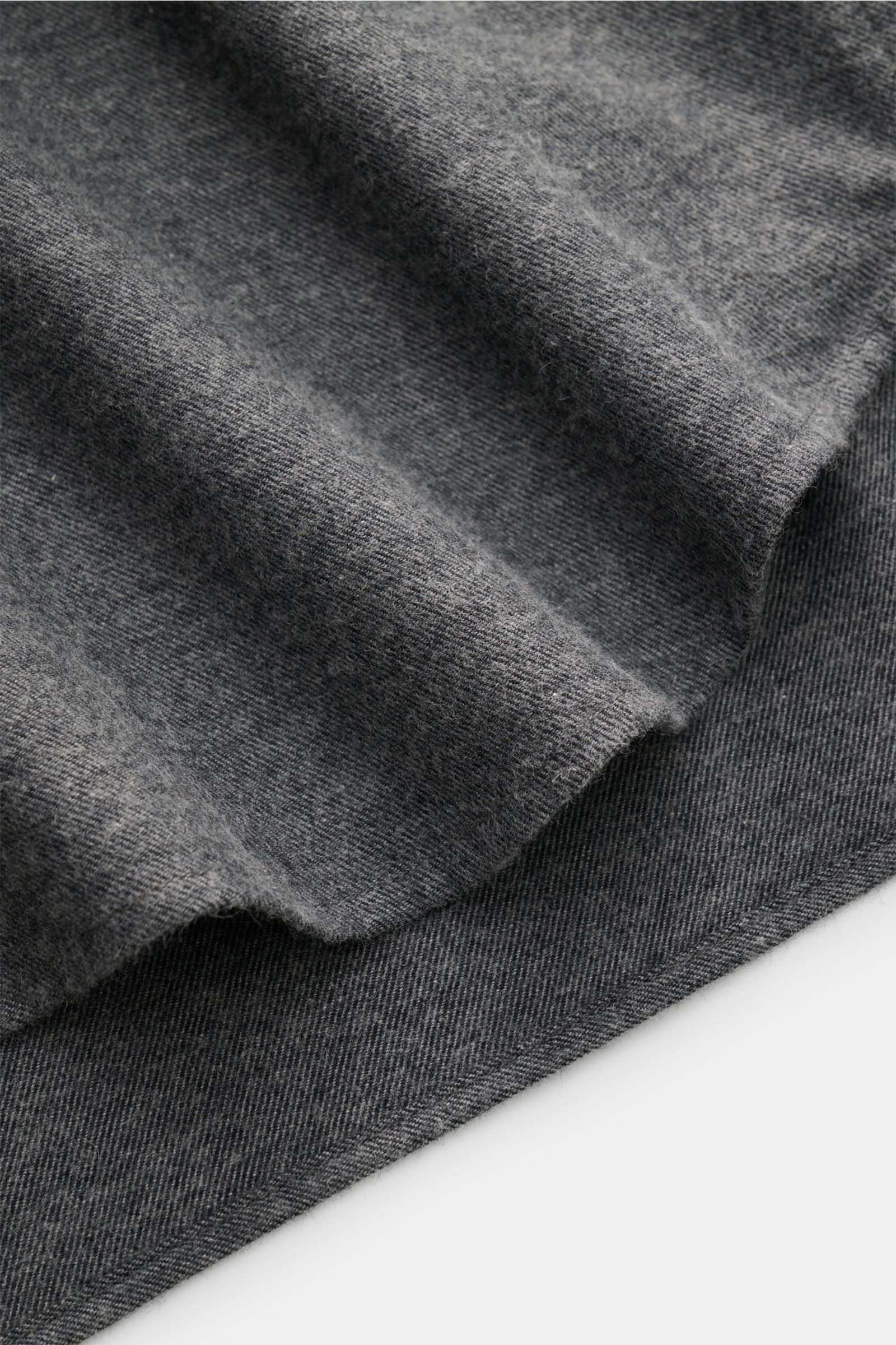 Close-up view of the fabric and rounded hem of the Guglielminotti Flannel shirt shark collar dark grey melange, made of cotton and cashmere flannel with a soft feel, regular fit, shark collar, French button placket, classic barrel cuffs, and waist darts a