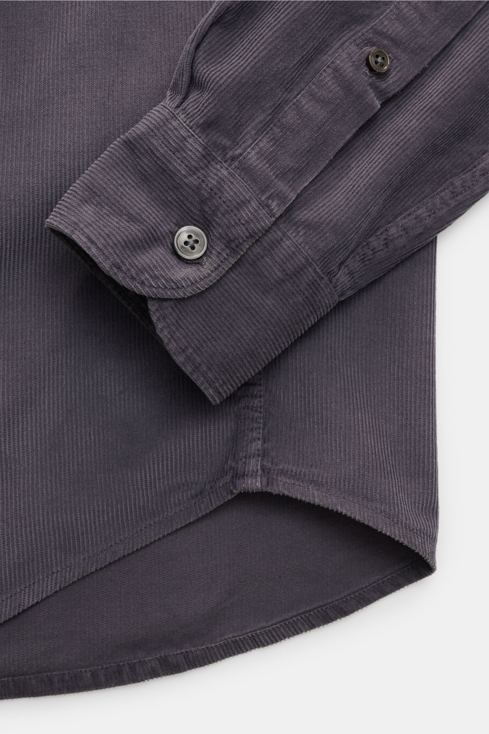 Close-up view of the cuff and hem of the Closed Cordhemd Button-Down-Kragen dunkelgrau, showing soft garment-dyed fine cotton corduroy with a button-down cuff and rounded hem.

Description: Perfekt für den Herbst: Das stückgefärbte Feincord-Hemd von CLOSE