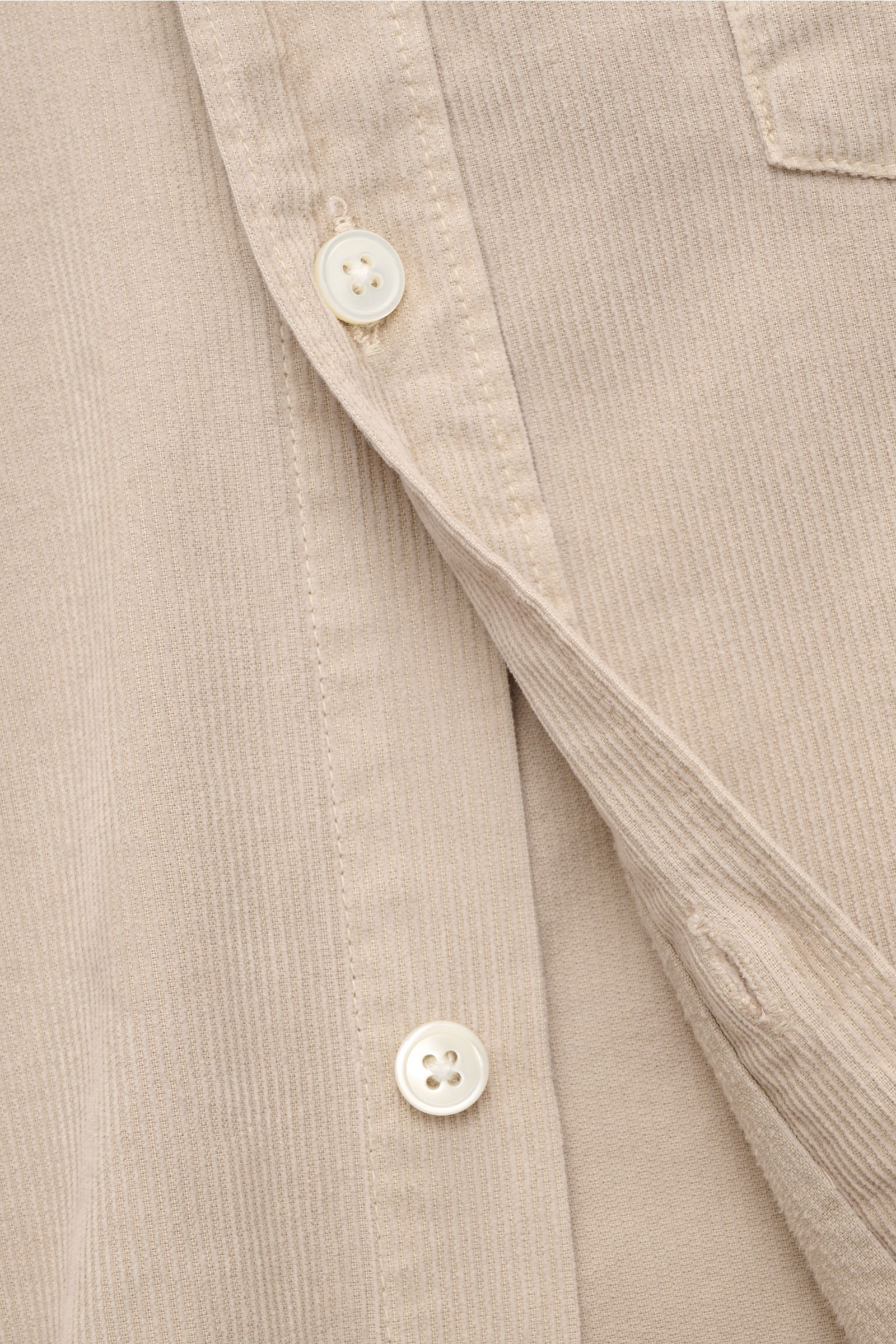 Close-up front view of the beige Closed Cordhemd Button-Down-Kragen showing soft fine cord fabric, pearl buttons, and detailed stitching, perfect for autumn wear. Perfekt für den Herbst: Das stückgefärbte Feincord-Hemd von CLOSED verbindet warmen, soft