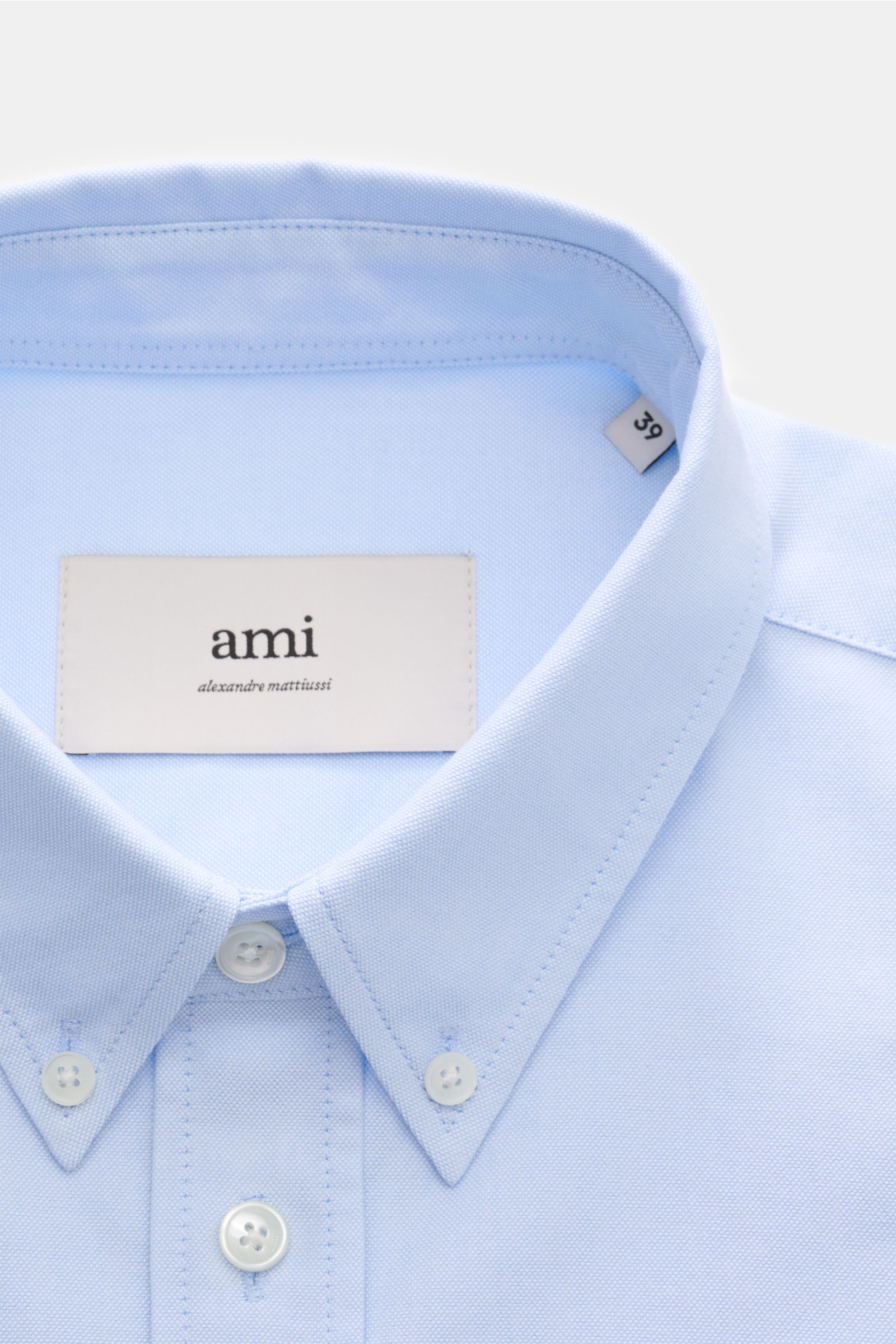 Nahaufnahme des hellblauen Ami Paris Oxford-Hemd Button-Down-Kragen aus reiner Baumwolle mit markentypischem Stick, Knopfleiste und Oversized Fit.