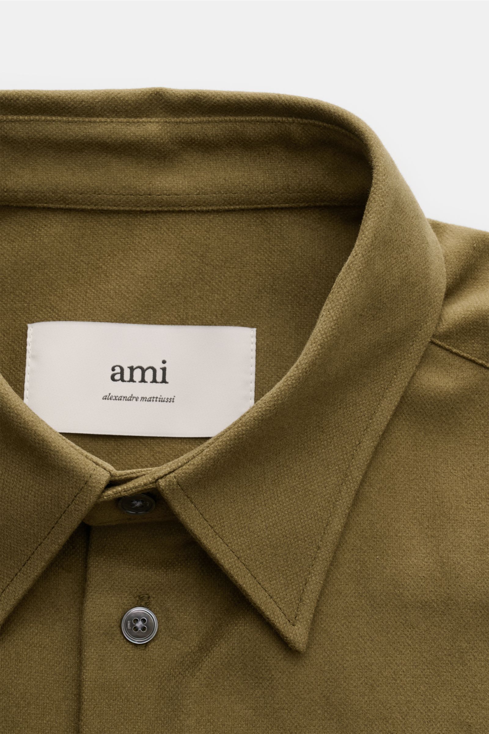 Close-up front view of Ami Paris Casual Hemd Kent-Kragen taupe shirt collar and top buttons, showcasing pure cotton fabric and fine details.

Description: Stilvoller Klassiker mit Liebe zum Detail: Dieses sportlich-lässige Hemd von AMI PARIS aus reiner