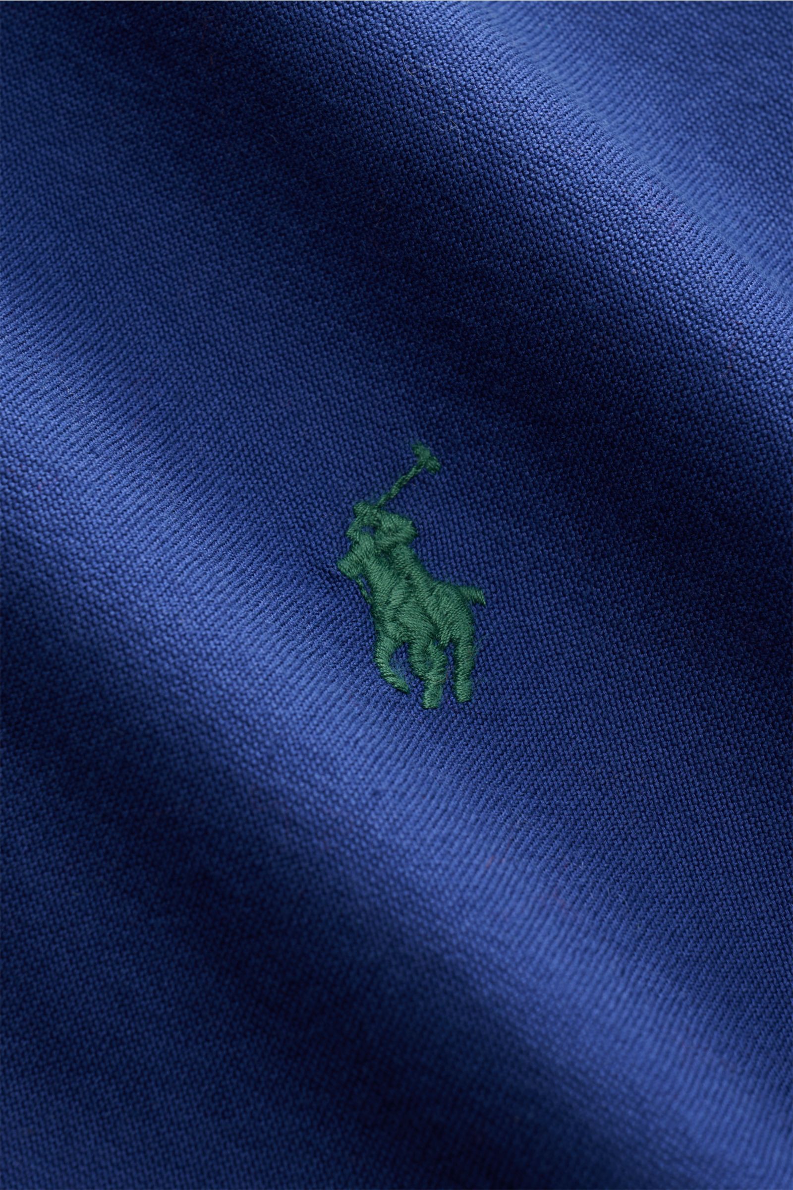 Close-up of the green multicolored Polo player stitching on the dark blue fabric of the Polo Ralph Lauren Oxford-Hemd Button-Down-Kragen dunkelblau, photographed from a frontal perspective. Stilvoller Klassiker mit Liebe zum Detail: Dieses sportliche H