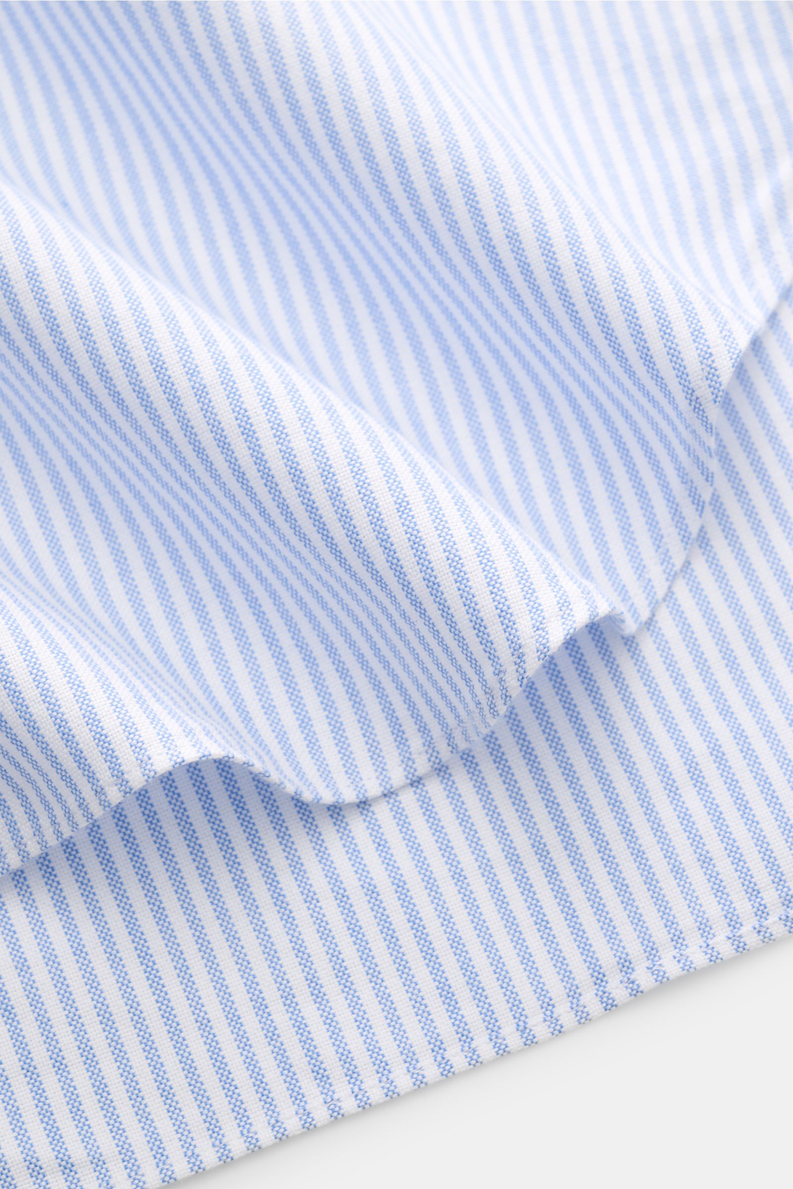 Finamore Oxford Hemd 'Edoardo Gaeta' Haifisch-Kragen hellblau/weiß gestreift, Detailaufnahme des gerundeten Saums aus Oxford Baumwolle, Regular Fit, leicht griffig, extralange Ärmel, französische Knopfleiste, klassische Sportmanschette.
