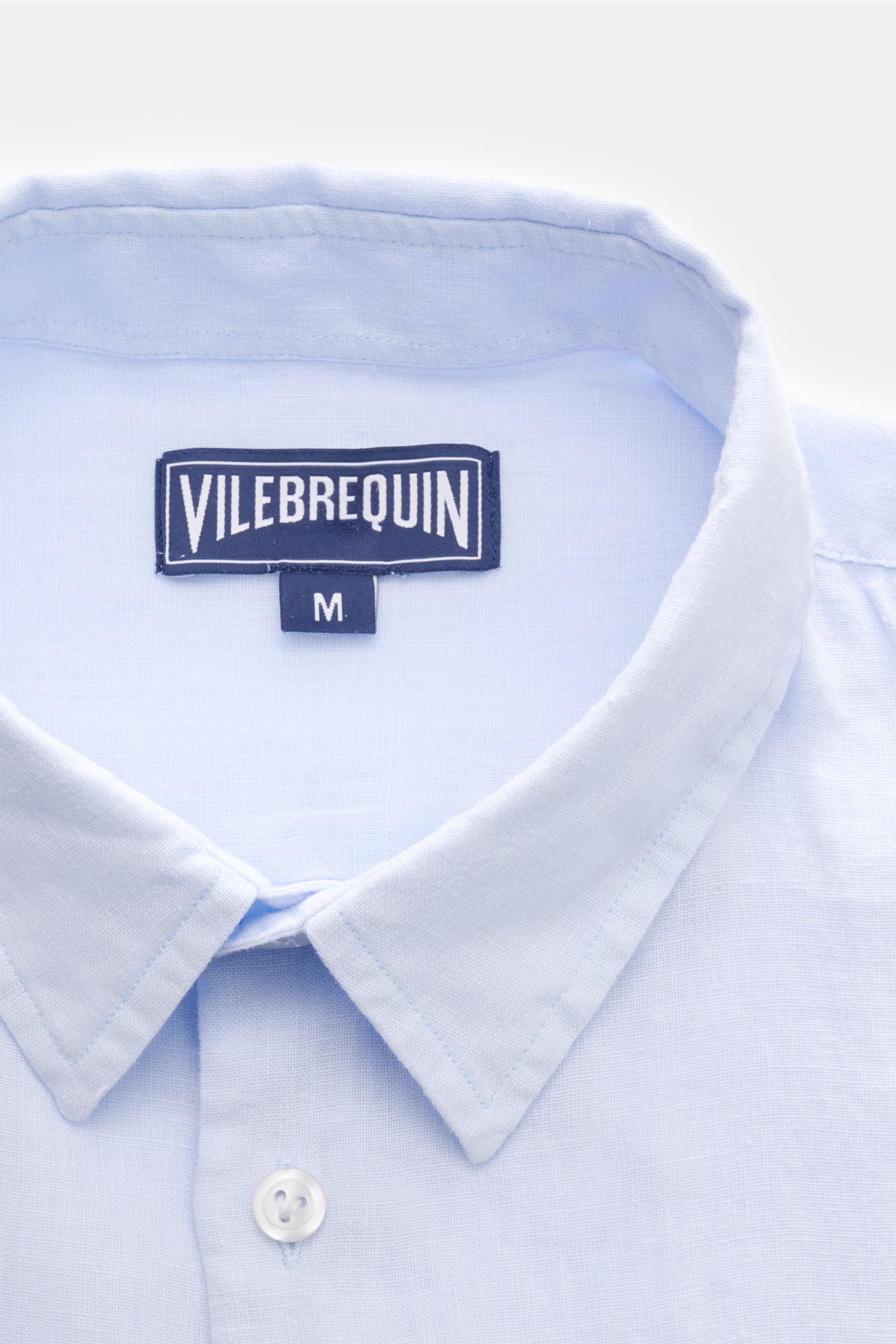 Nahaufnahme des Vilebrequin Leinenhemds schmaler Kragen pastellblau von oben, reines Leinen, luftige Leinwandbindung, leichte Qualität, weicher Griff, Regular Fit, schmaler Kragen, französische Knopfleiste, klassische Sportmanschette, aufgesetzte Brusttas