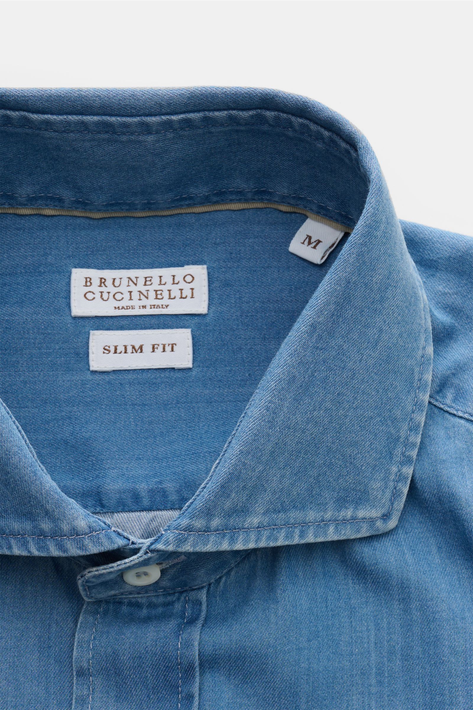 Close-up front view of the Brunello Cucinelli Casual Hemd Haifisch-Kragen rauchblau showing the shark collar and slim fit label in soft, denim-look cotton twill.

Description: Dieses Casual Hemd aus reiner, softer Baumwolle von BRUNELLO CUCINELLI ist d
