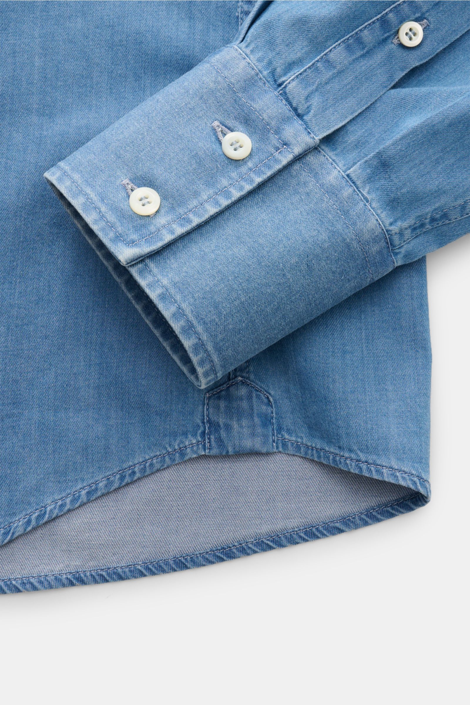 Close-up front-side view of the cuff and hem of the Brunello Cucinelli Casual Hemd Haifisch-Kragen rauchblau in soft cotton twill denim look.

Description for more detail:  
Dieses Casual Hemd aus reiner, softer Baumwolle von BRUNELLO CUCINELLI ist das
