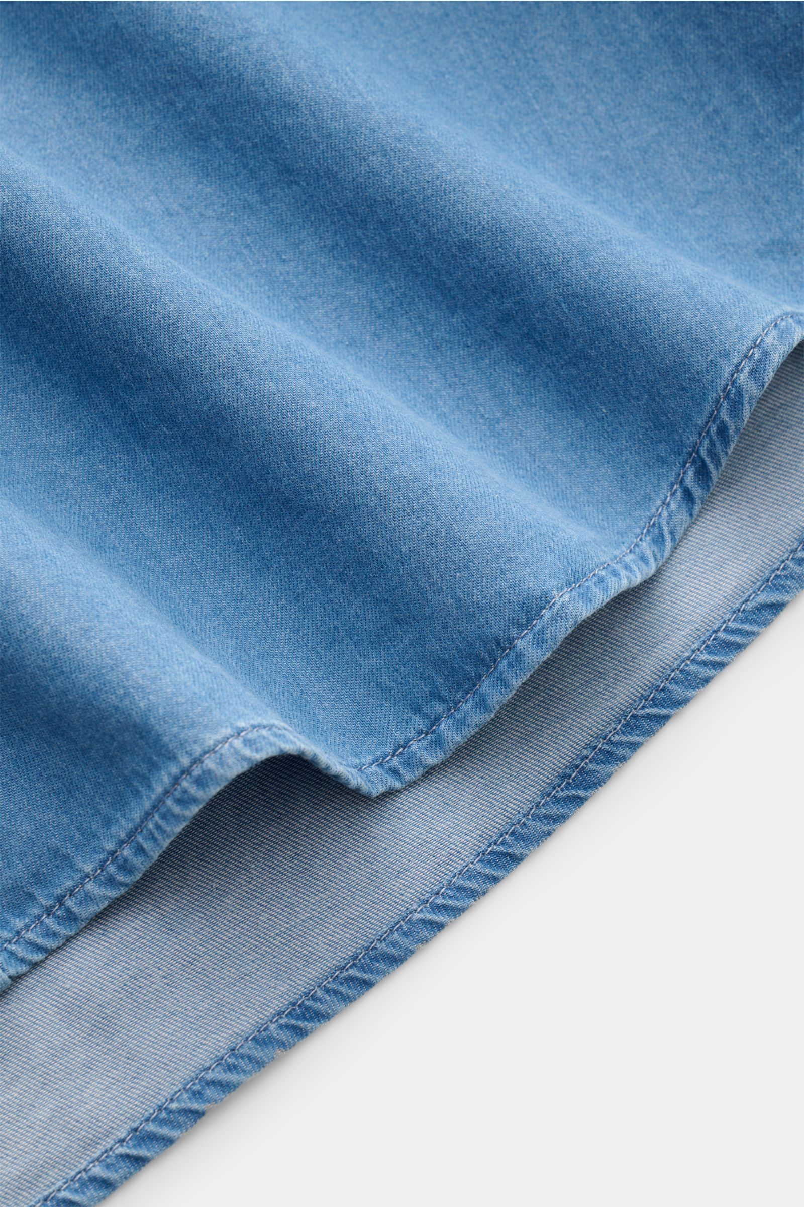 Close-up of the hem of the Brunello Cucinelli Casual Hemd Haifisch-Kragen rauchblau, showing soft cotton twill fabric in a denim look from a side angle.

Description: Dieses Casual Hemd aus reiner, softer Baumwolle von BRUNELLO CUCINELLI ist das perfek