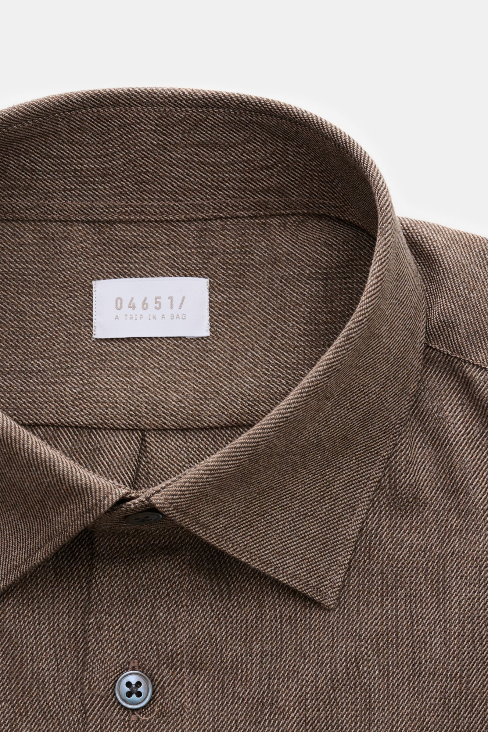 Close-up front top view of the 04651/ A trip in a bag Casual Hemd 'Rustic Shirt' Kent-Kragen dunkelgrau showing its Kent collar and button detail, made from 100% brushed cotton with a soft touch.

Lässiger Stil trifft auf Komfort: Das 'Rustic Shirt' vo