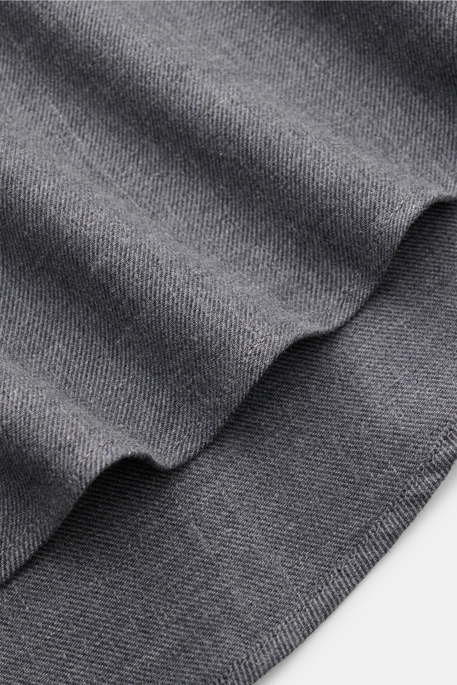 Close-up view of the soft, brushed 100% cotton fabric of the 04651/ A trip in a bag Casual Hemd 'Rustic Shirt' Kent-Kragen dunkelgrau, showcasing its durable, dark gray texture and fine weave. Lässiger Stil trifft auf Komfort: Das 'Rustic Shirt' von 04