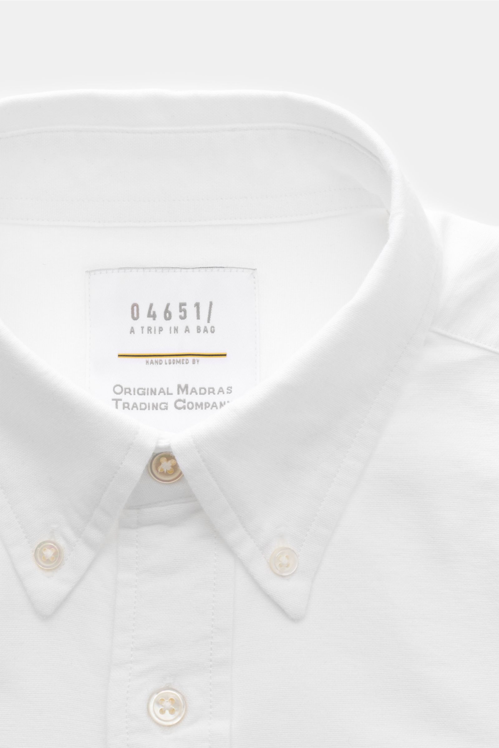 Close-up front view of 04651/ A trip in a bag Oxford-Hemd Button-Down-Kragen weiß, showing button-down collar and buttons.

Stilvoller Begleiter im Alltag: Das 'Handloomed Oxford Shirt' von 04651/ A TRIP IN A BAG wird mit seinem exklusiven Material aus