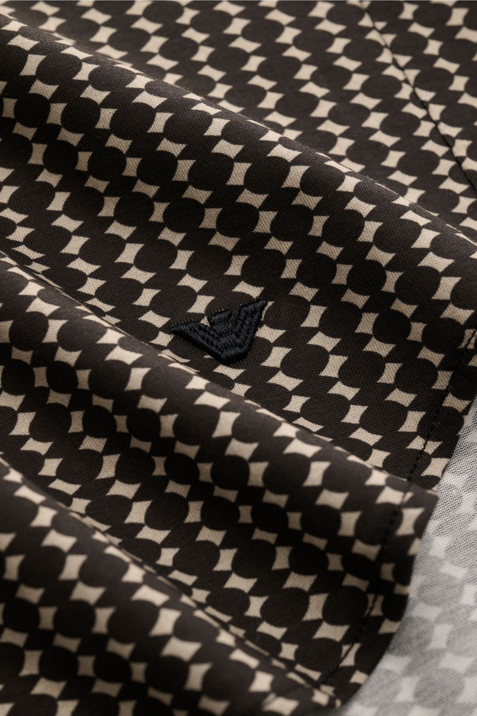 Close-up view of the patterned fabric and logo embroidery on the cuff of the Emporio Armani Casual Hemd Kent-Kragen grau/schwarz gemustert. Eyecatcher im Retro-Look: Das Hemd von EMPORIO ARMANI setzt als markantes Key-Piece moderne Akzente in urbanen Look