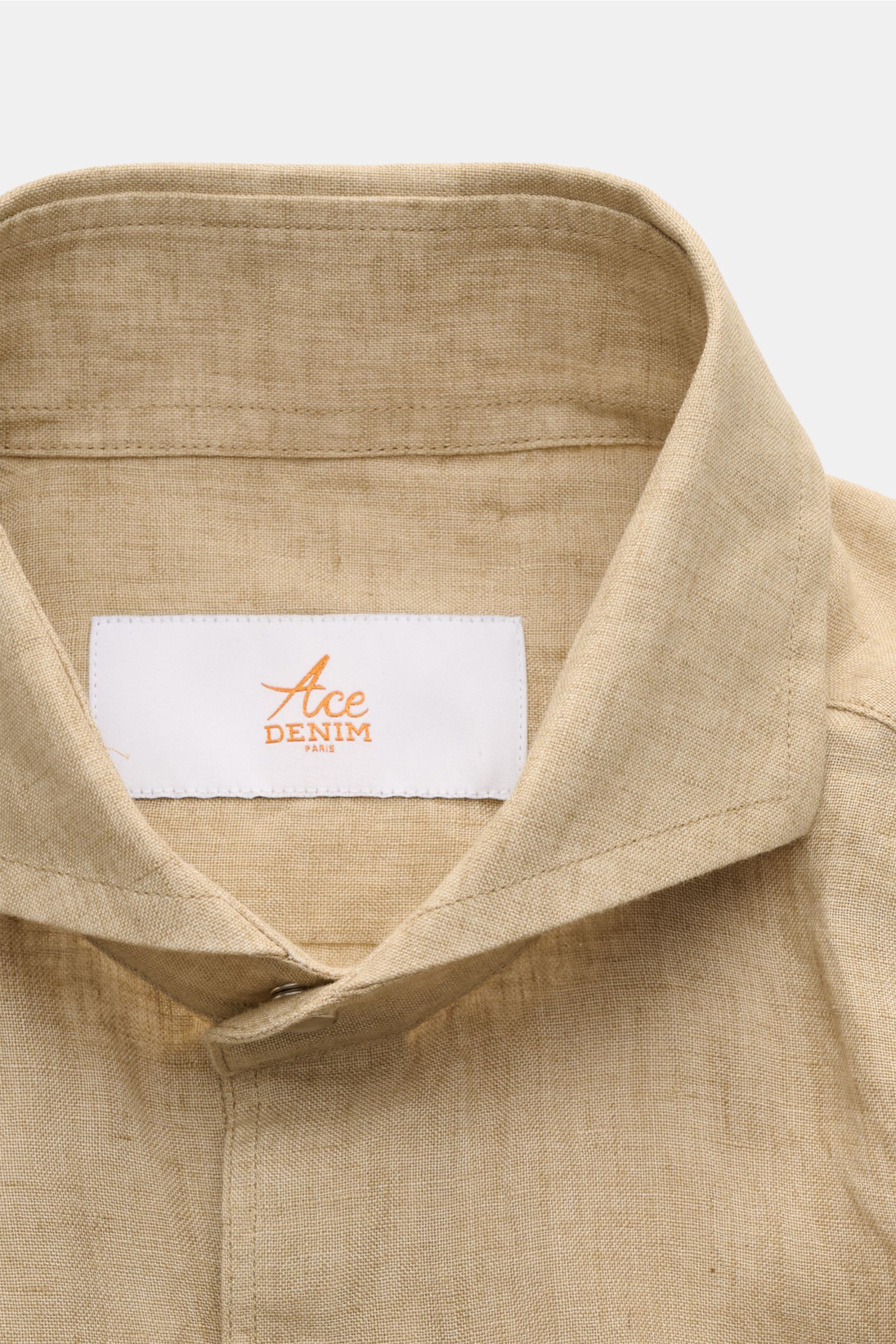 Close-up front view of Ace Denim Linen shirt shark collar beige showcasing its pure linen, lightweight fabric, shark collar, and French button placket with snap buttons. 

Stay comfortable in the warmer months: This ACE DENIM shirt in lightweight linen