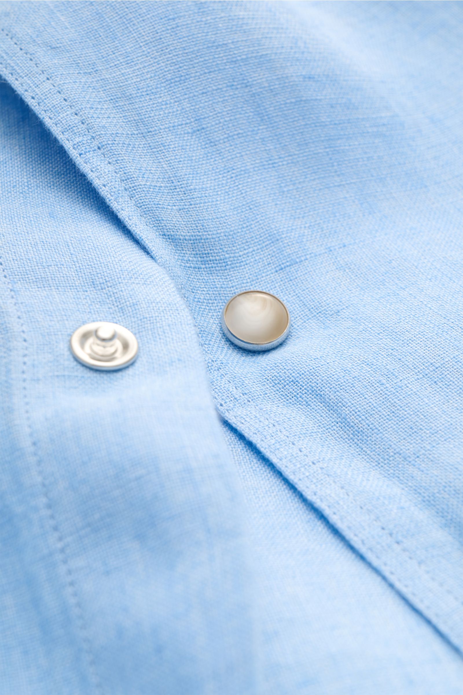 Close-up image of the Ace Denim Linen shirt shark collar light blue, showing lightweight linen fabric and snap button detail from a top-front perspective. Stay comfortable in the warmer months: This ACE DENIM shirt in lightweight linen fabric is a casual 