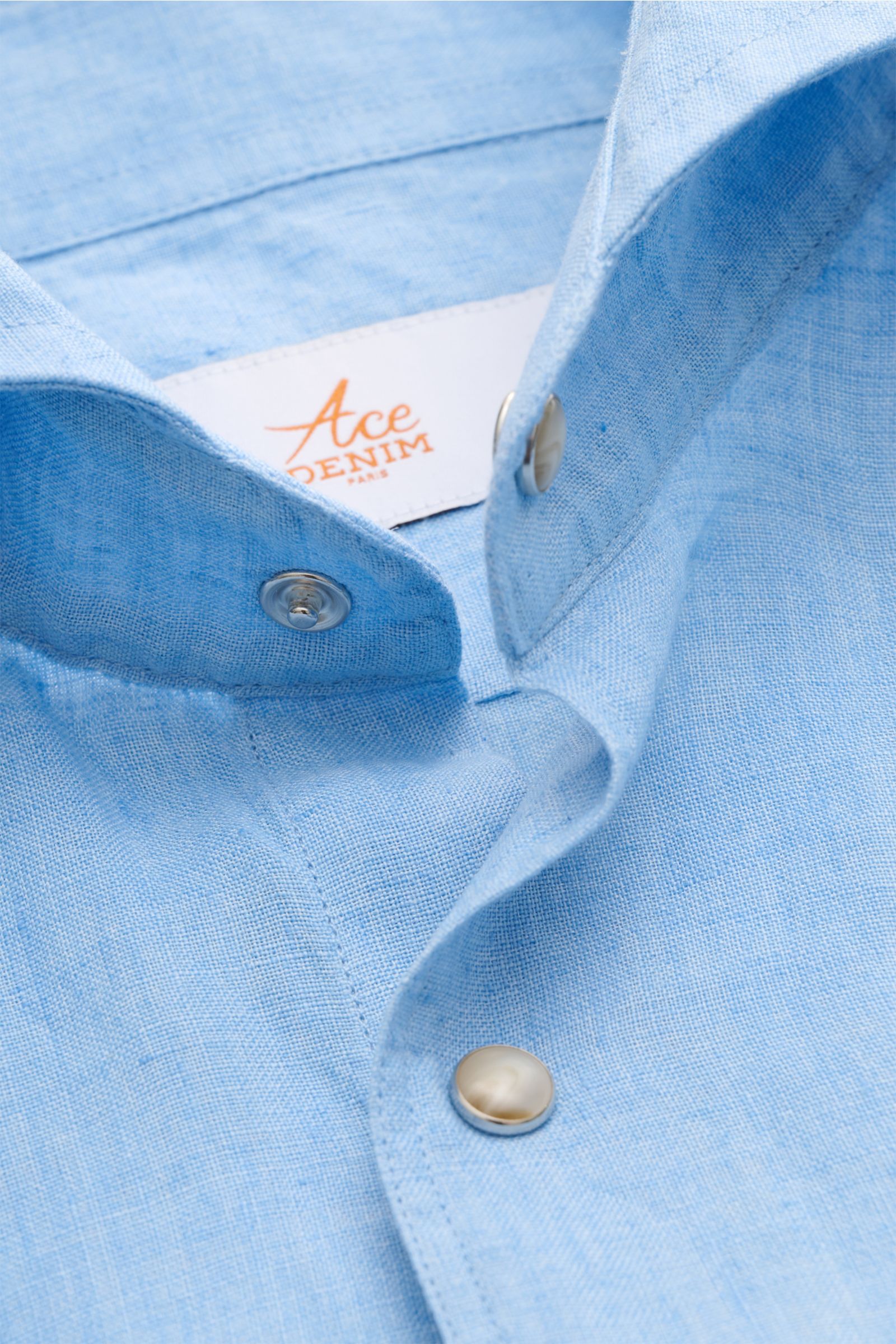Close-up front angle of Ace Denim Linen shirt shark collar light blue showing lightweight pure linen fabric, snap buttons, and fine yarn texture.

Description: Stay comfortable in the warmer months: This ACE DENIM shirt in lightweight linen fabric is a