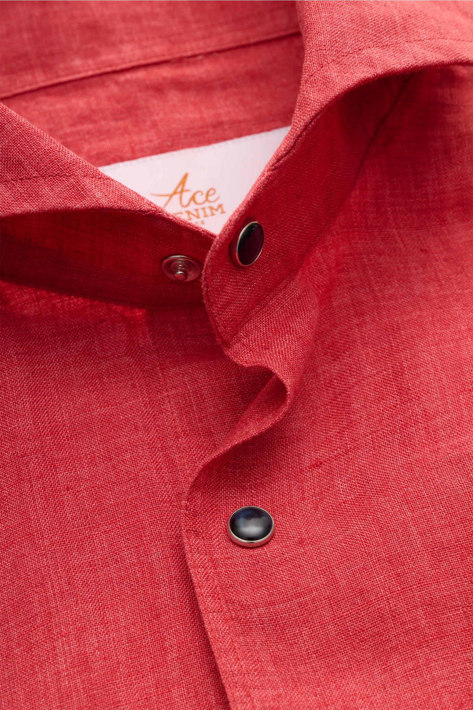 Close-up front view of Ace Denim Linen shirt shark collar red, showing red pure linen fabric, black snap buttons, and shark collar. Stay comfortable in the warmer months: This ACE DENIM shirt in lightweight linen fabric is a casual statement piece for 