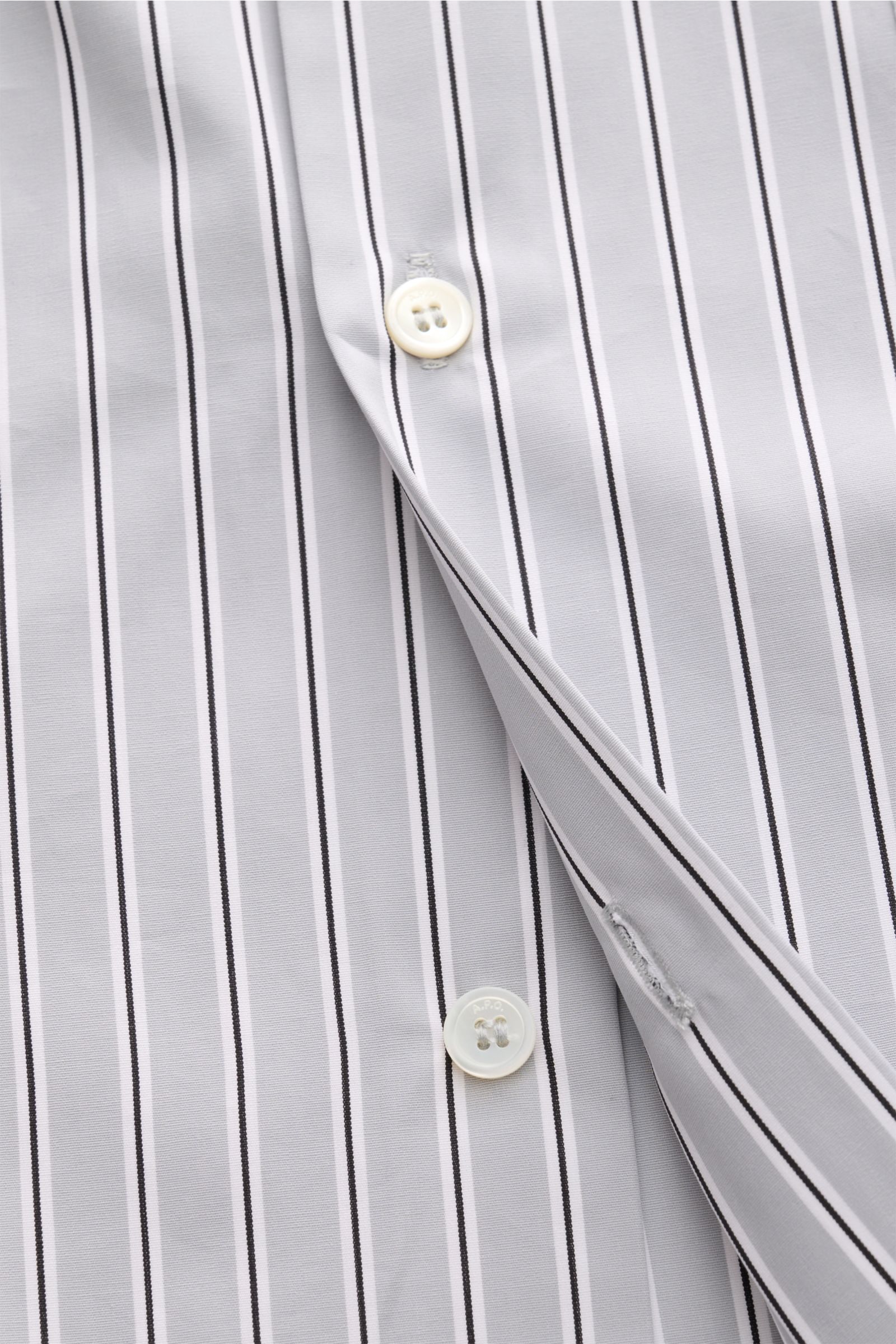Nahaufnahme aus schräger Perspektive des A.P.C. Casual Hemd Kent-Kragen hellgrau/schwarz/weiß gestreift mit französischer Knopfleiste.