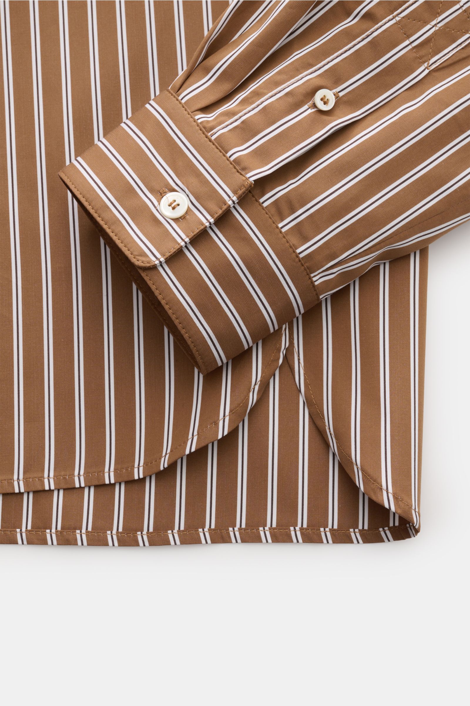 Nahaufnahme des Ärmels und Saumverlaufs des A.P.C. Casual Hemd Kent-Kragen braun/schwarz/weiß gestreift aus reiner Baumwolle mit Oversized Fit.
