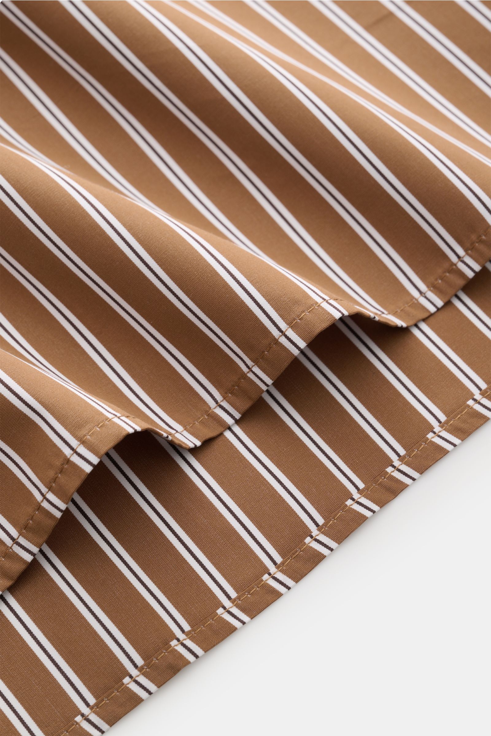 Nahaufnahme des Saumverlaufs vom A.P.C. Casual Hemd Kent-Kragen braun/schwarz/weiß gestreift aus reiner Baumwolle mit glattem Griff und Oversized Fit.