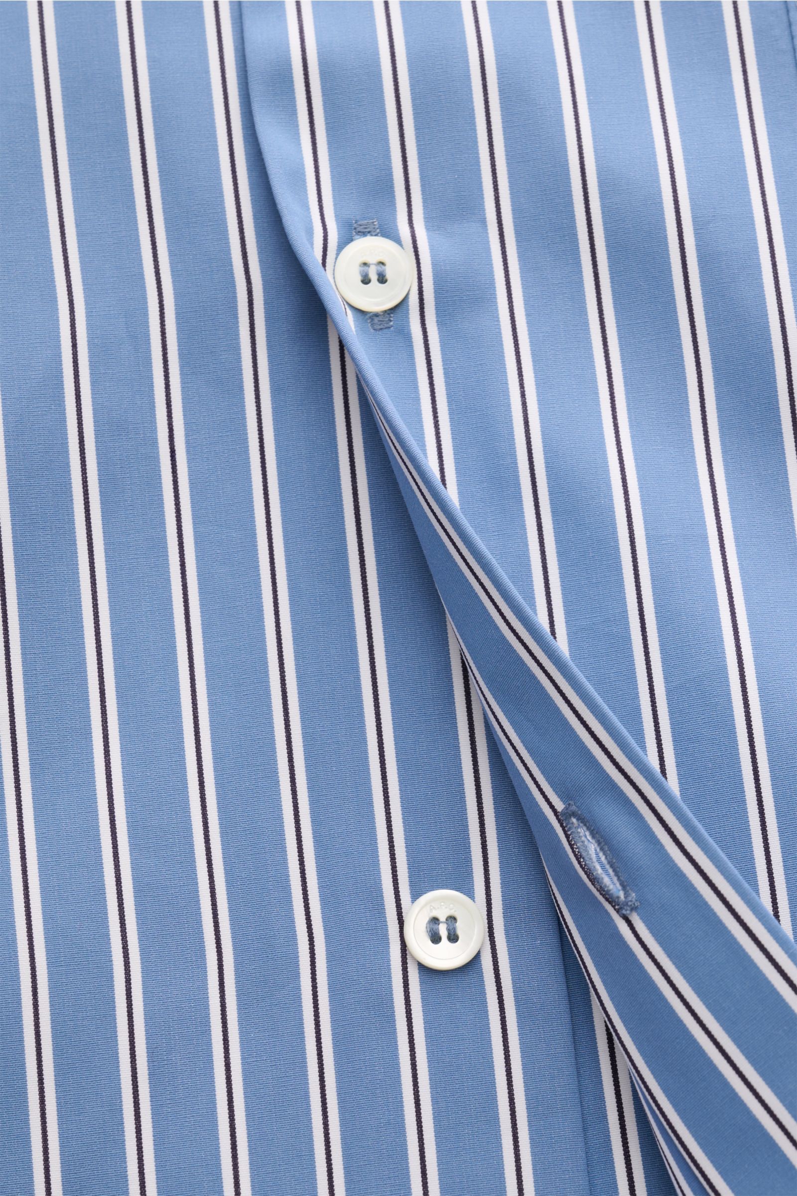 Nahaufnahme der Knopfleiste des A.P.C. Casual Hemd Kent-Kragen graublau/schwarz/weiß gestreift aus glatter Baumwolle mit Oversized Fit.