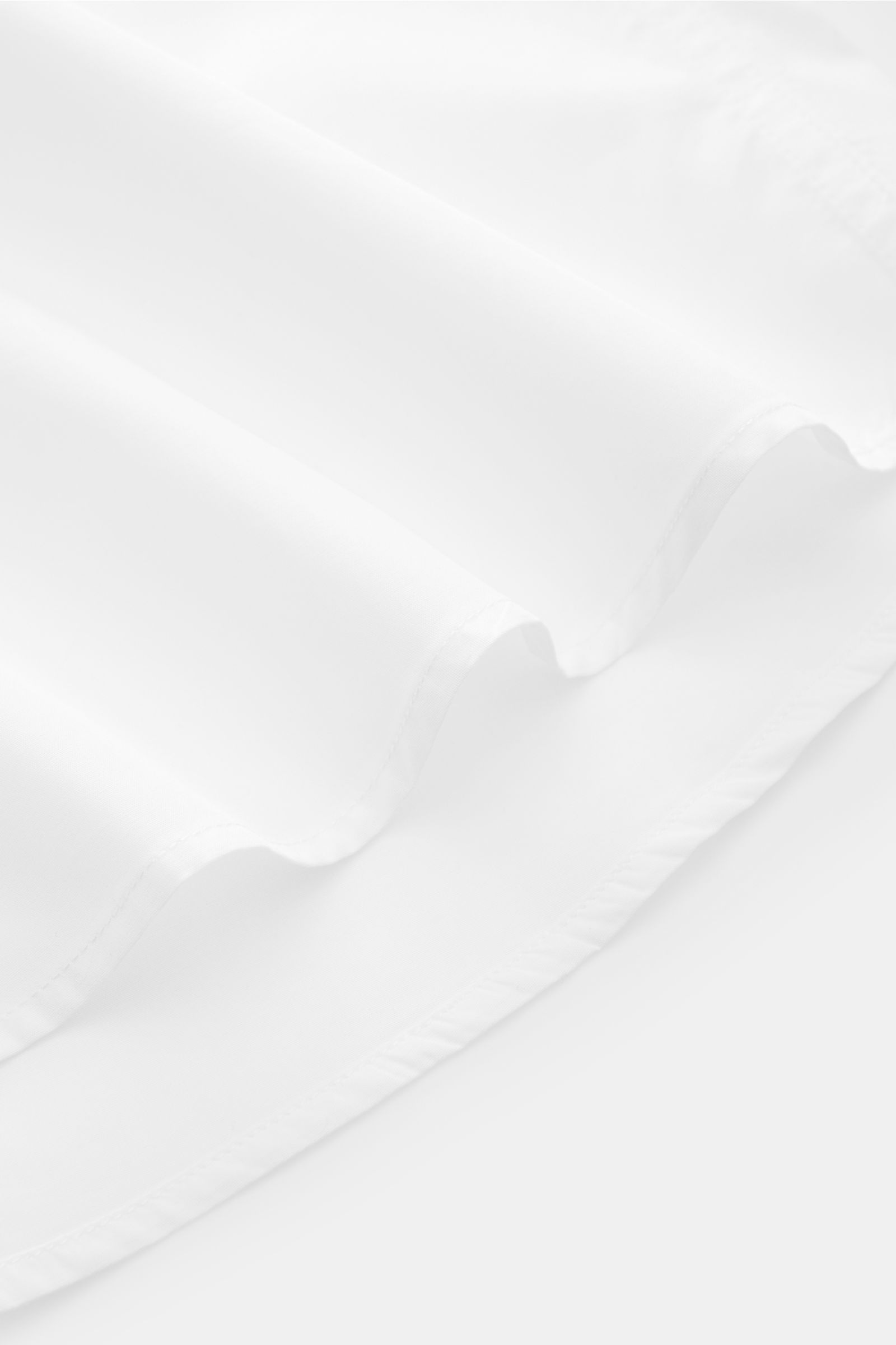 A.P.C. Casual shirt Kent collar white shown from a close-up side angle, highlighting the slightly rounded hem and smooth pure cotton fabric. A modern take on a classic look: This shirt by A.P.C. has a timeless aesthetic. It works as well in stylish office