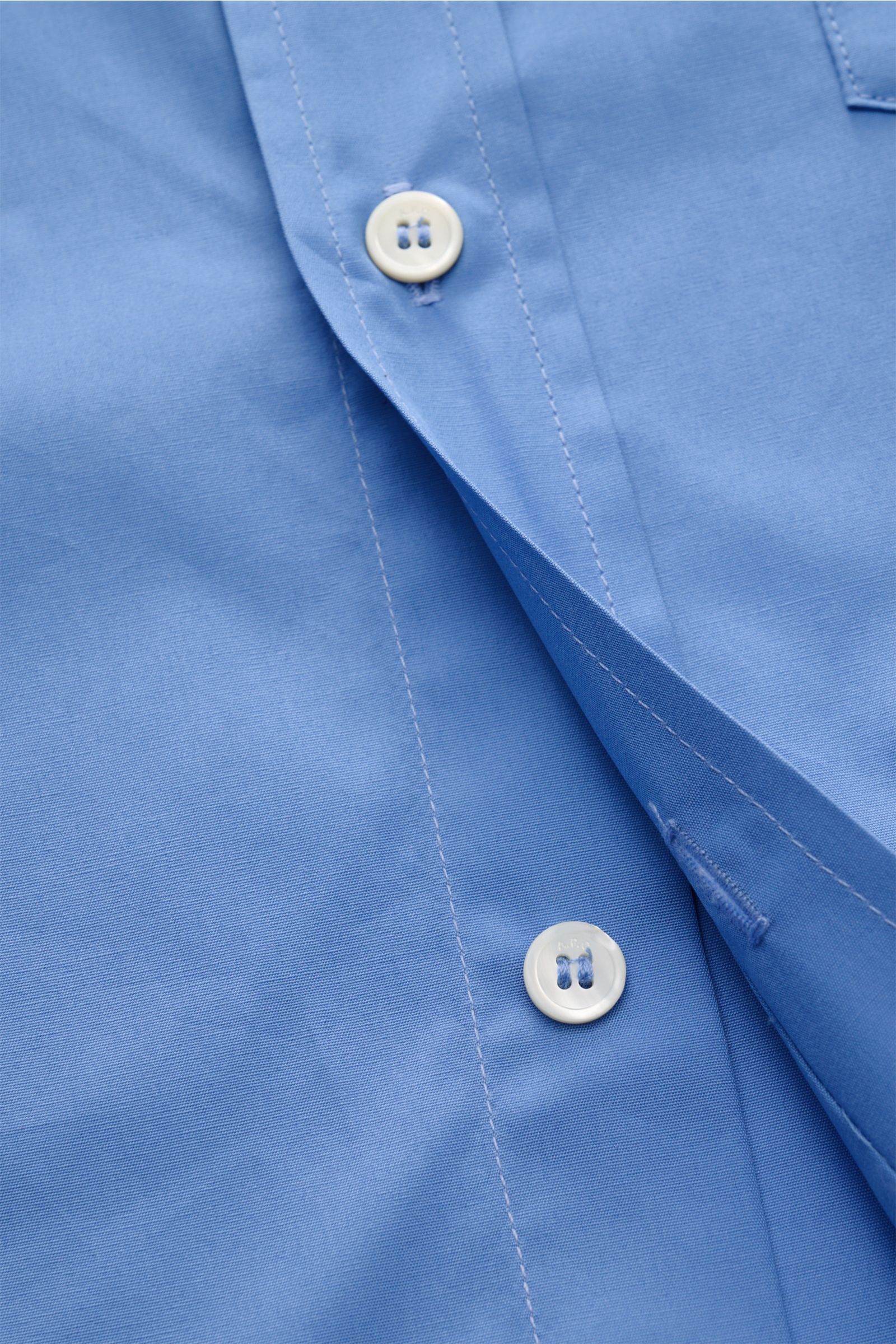 Close-up front view of the A.P.C. Casual shirt Kent collar blue showing white buttons, patch button placket, and smooth pure cotton fabric. A modern take on a classic look: This shirt by A.P.C. has a timeless aesthetic. It works as well in stylish office 